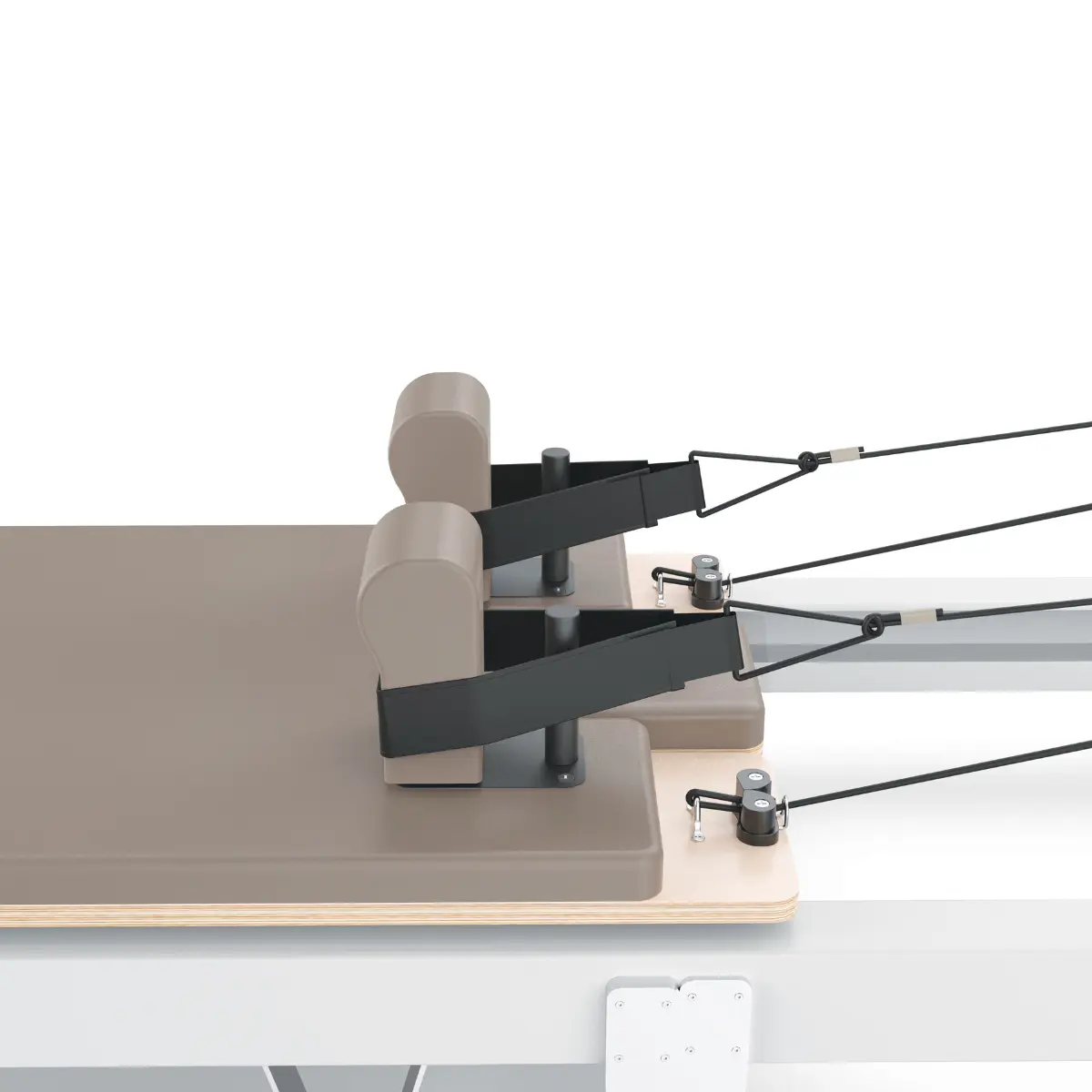 Pilates reformer machine with beige pads, black straps, and white background.  Focus on the equipment's details.