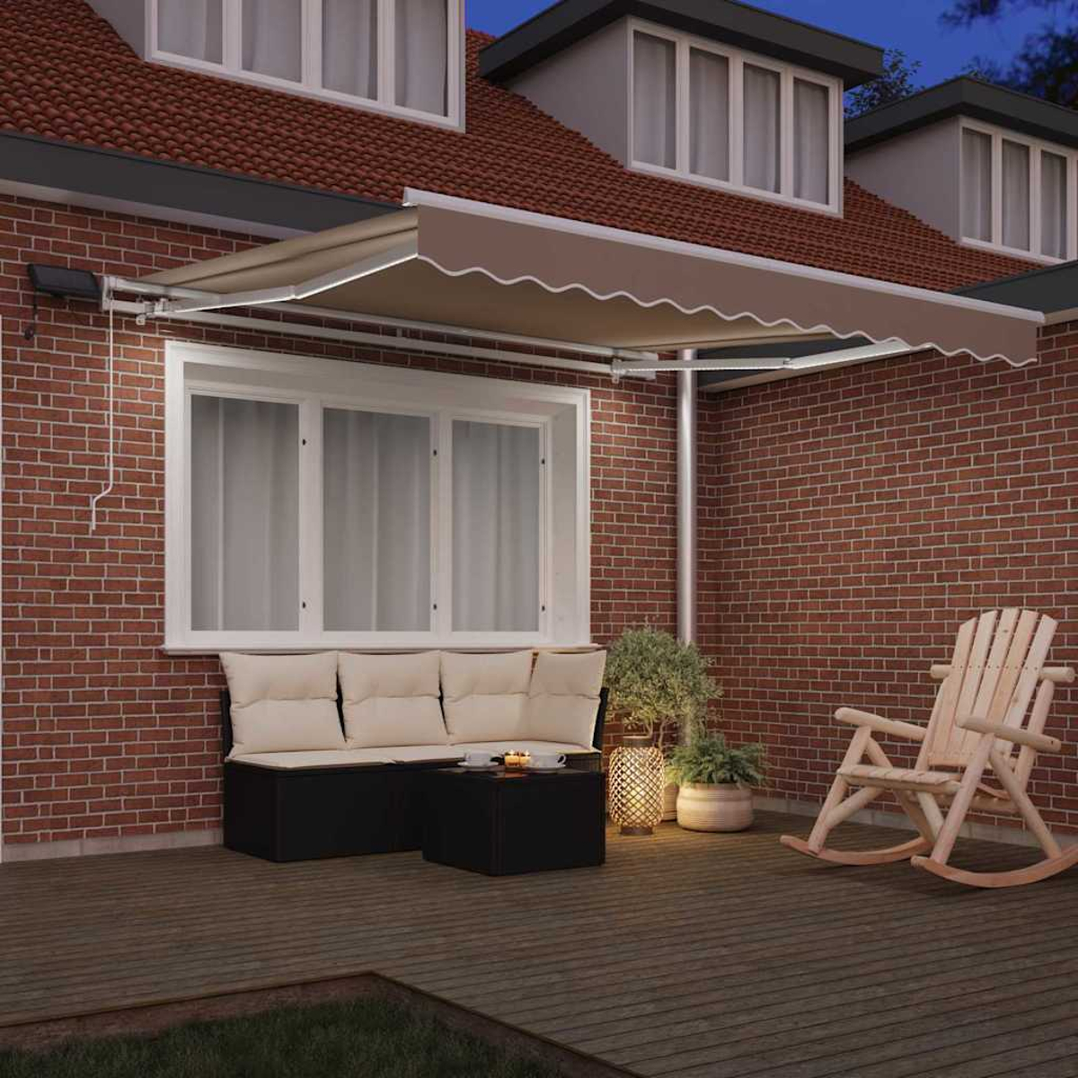 Un patio con toldo marrón, asientos, una mecedora y plantas. Pared de ladrillo rojo y cubierta de madera. Escena nocturna.
