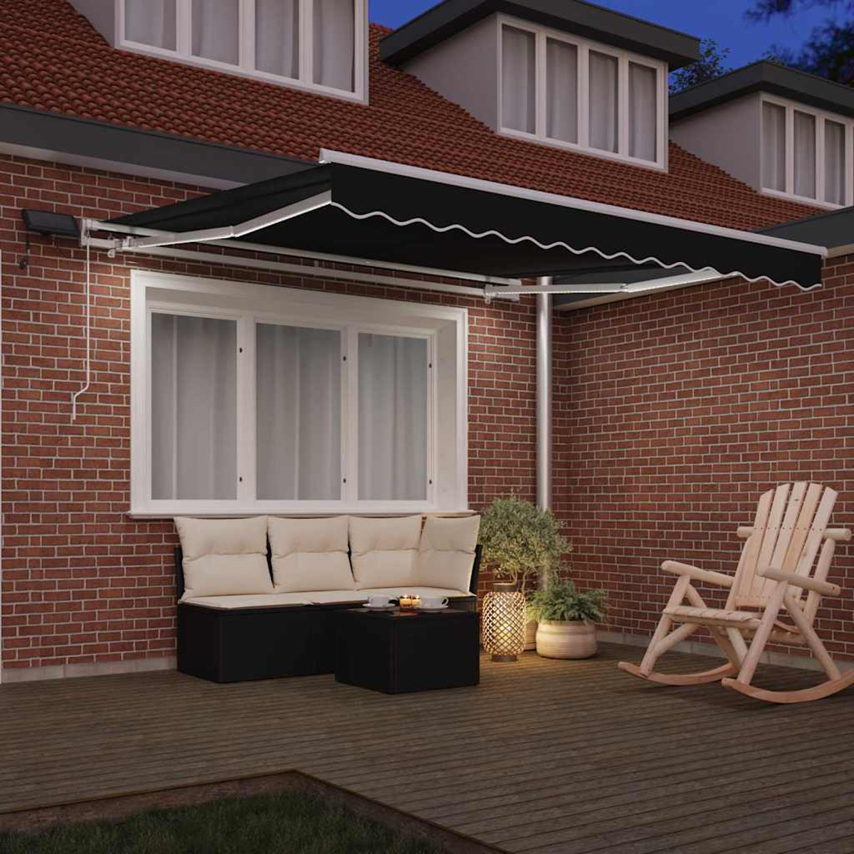 Eine Terrasse mit schwarzer Markise, Sitzgelegenheiten und einem Schaukelstuhl. Eine Backsteinmauer bildet den Hintergrund, während der Himmel dunkel ist.