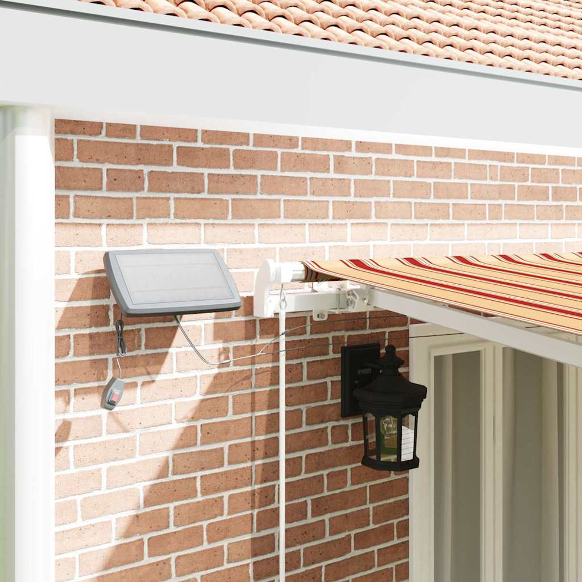Außenansicht: Backsteinmauer mit Markise, Solarpanel und Laterne. Markise hat rot-beige Streifen. Solarpanel an der Wand befestigt.