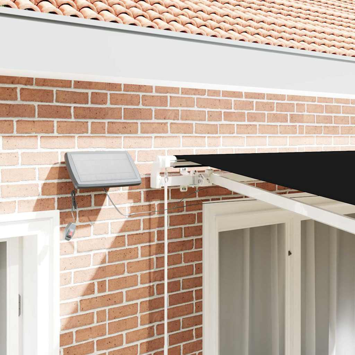 Eine Ziegelmauer mit Dach und schwarzer Markise. Eine graue Platte ist an der Wand befestigt. Es gibt ein Fenster und eine Fernbedienung.