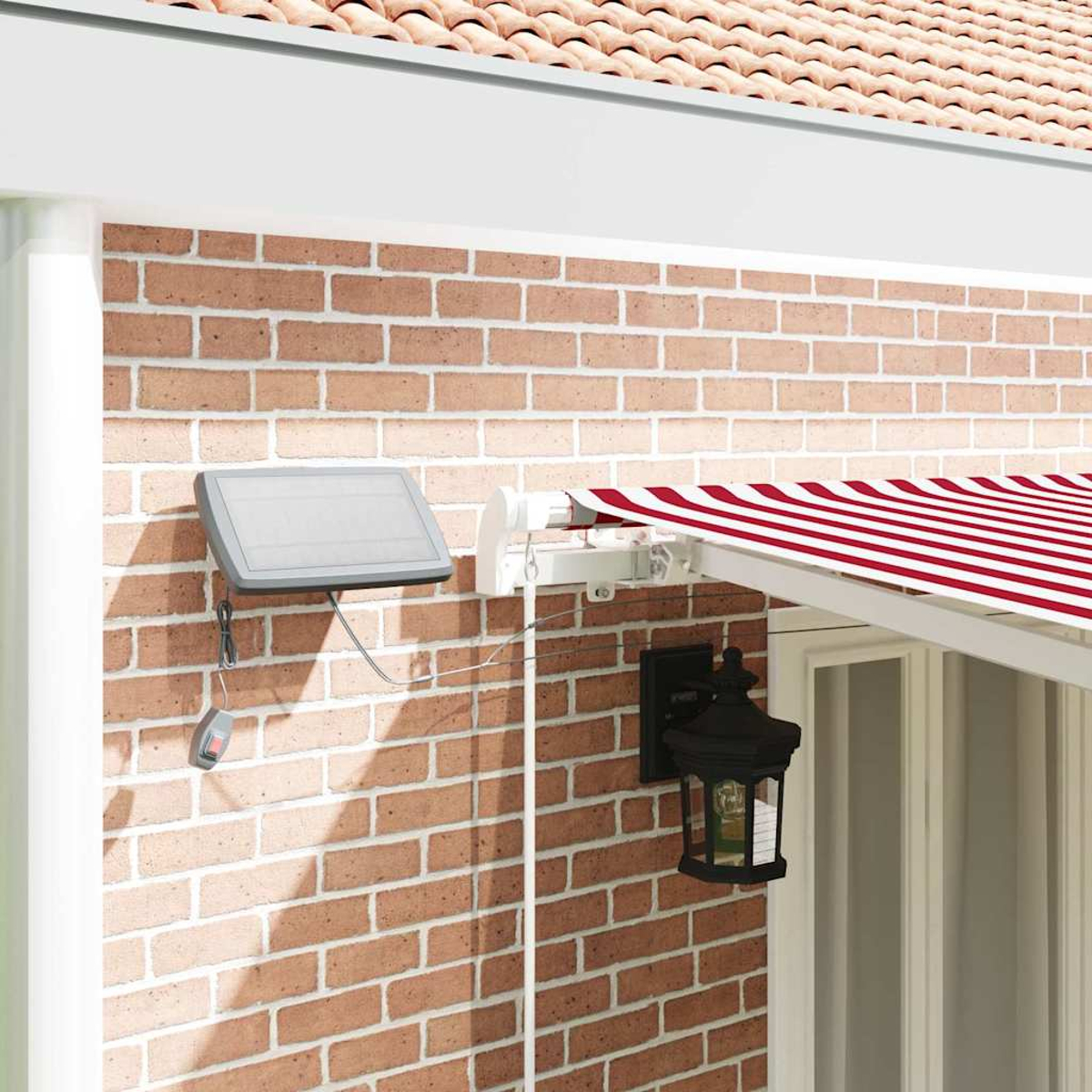 Eine Backsteinmauer mit Solarpanel, Markise und schwarzer Laterne. Die Markise hat rot-weiße Streifen. Eine Fernbedienung ist angeschlossen.