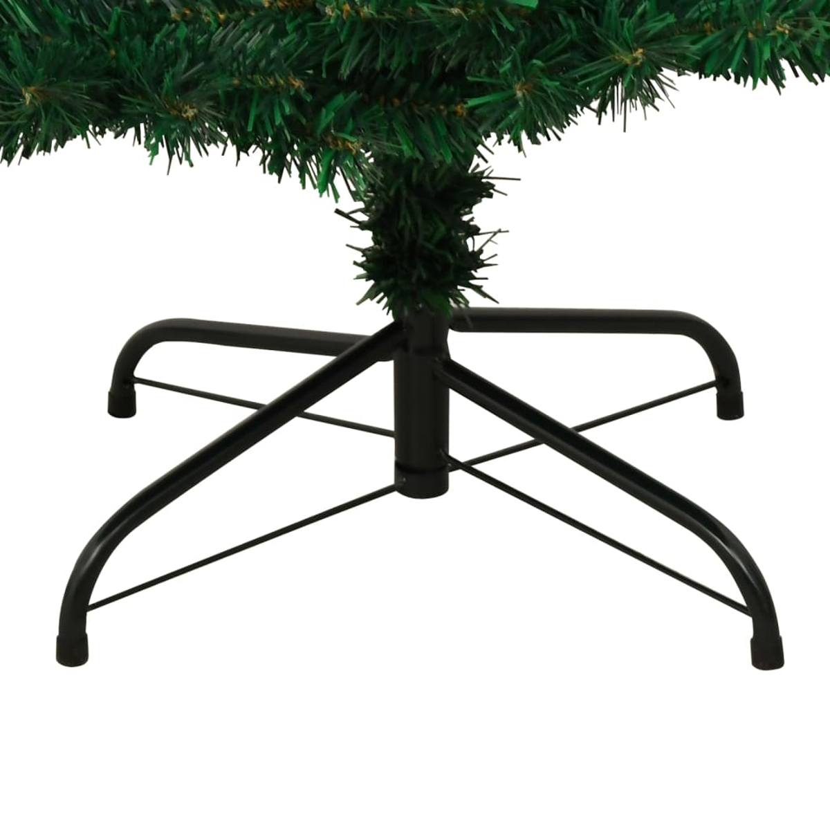 Nahaufnahme eines grünen Weihnachtsbaumfußes. Der schwarze Metallsockel ist sichtbar, mit den grünen Zweigen darüber. Weißer Hintergrund.