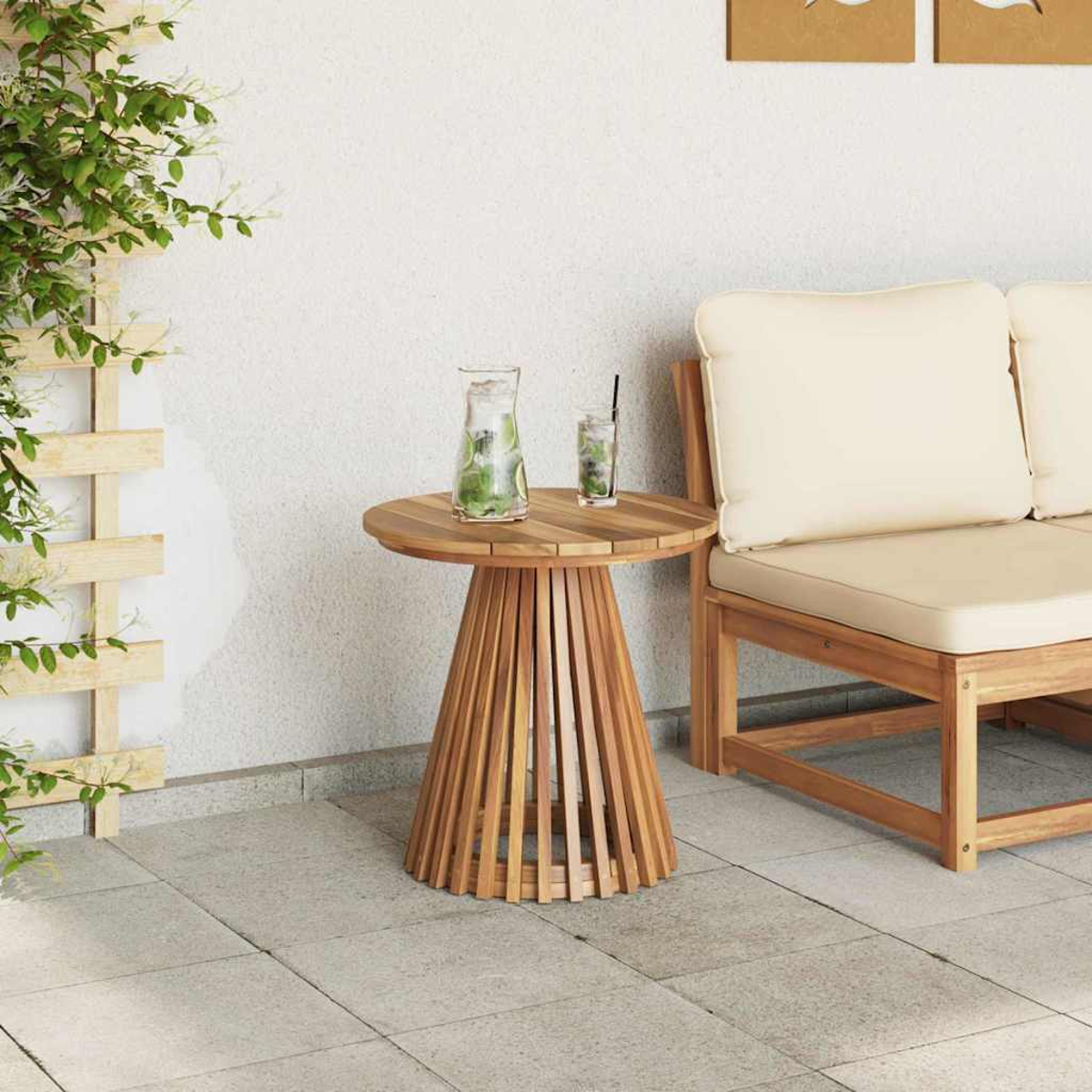Una mesa de madera con bebidas, un banco de madera con cojines crema y una planta trepadora en un enrejado de madera.