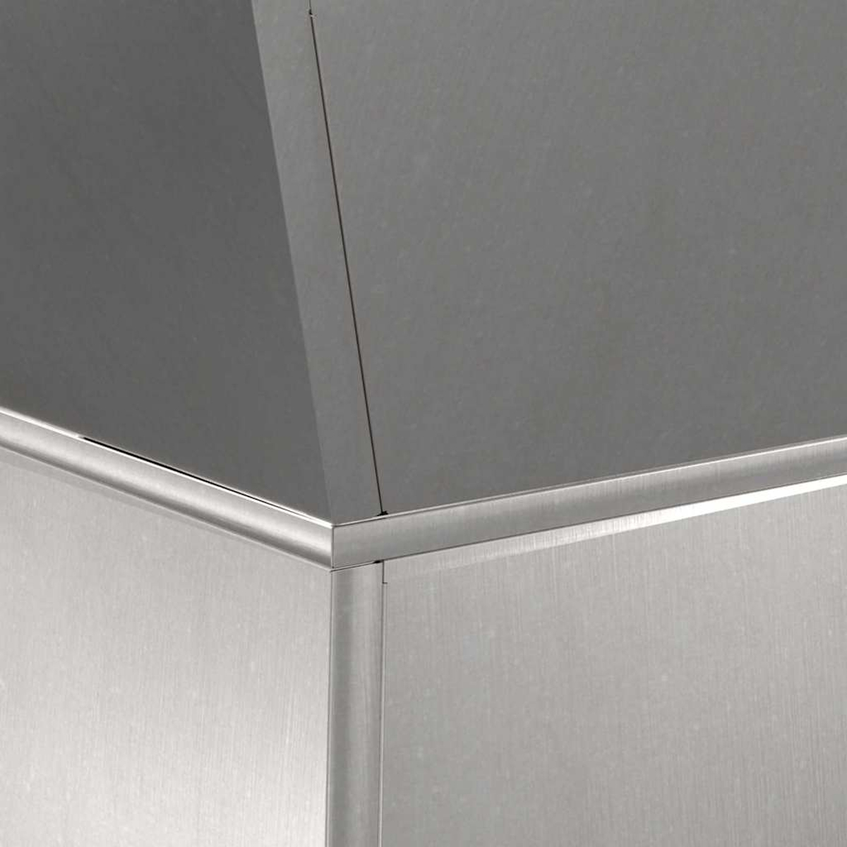 Primo piano di un angolo in acciaio inossidabile. L'angolo ha una texture di metallo spazzolato. La luce cattura il bordo e mette in evidenza le linee pulite.