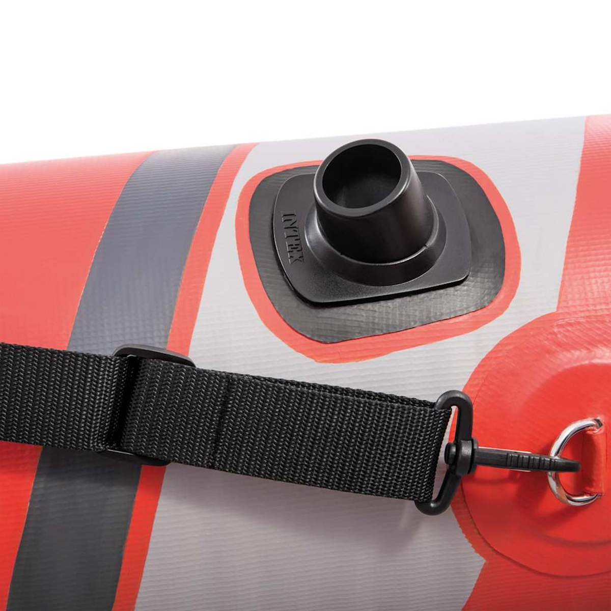 Nahaufnahme eines Schlauchbootes. Ein schwarzer Gurt und Griff sind sichtbar. Ein schwarzes Ventil befindet sich auf dem Boot. Das Boot hat rote, graue und weiße Farben.