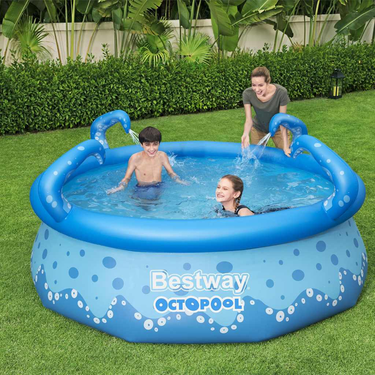 Ein blaues Pool mit Oktopus-Motiv hat drei Personen darin. Eine Frau gießt Wasser in den Pool. Grünes Gras und Büsche umgeben den Pool.