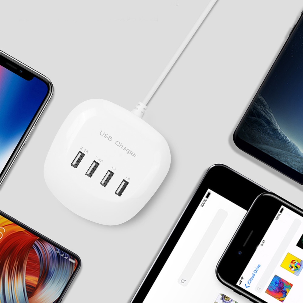 Ein weißes USB-Ladegerät mit vier Anschlüssen ist mit mehreren Smartphones und Tablets verbunden, die alle auf einer hellgrauen Oberfläche liegen.