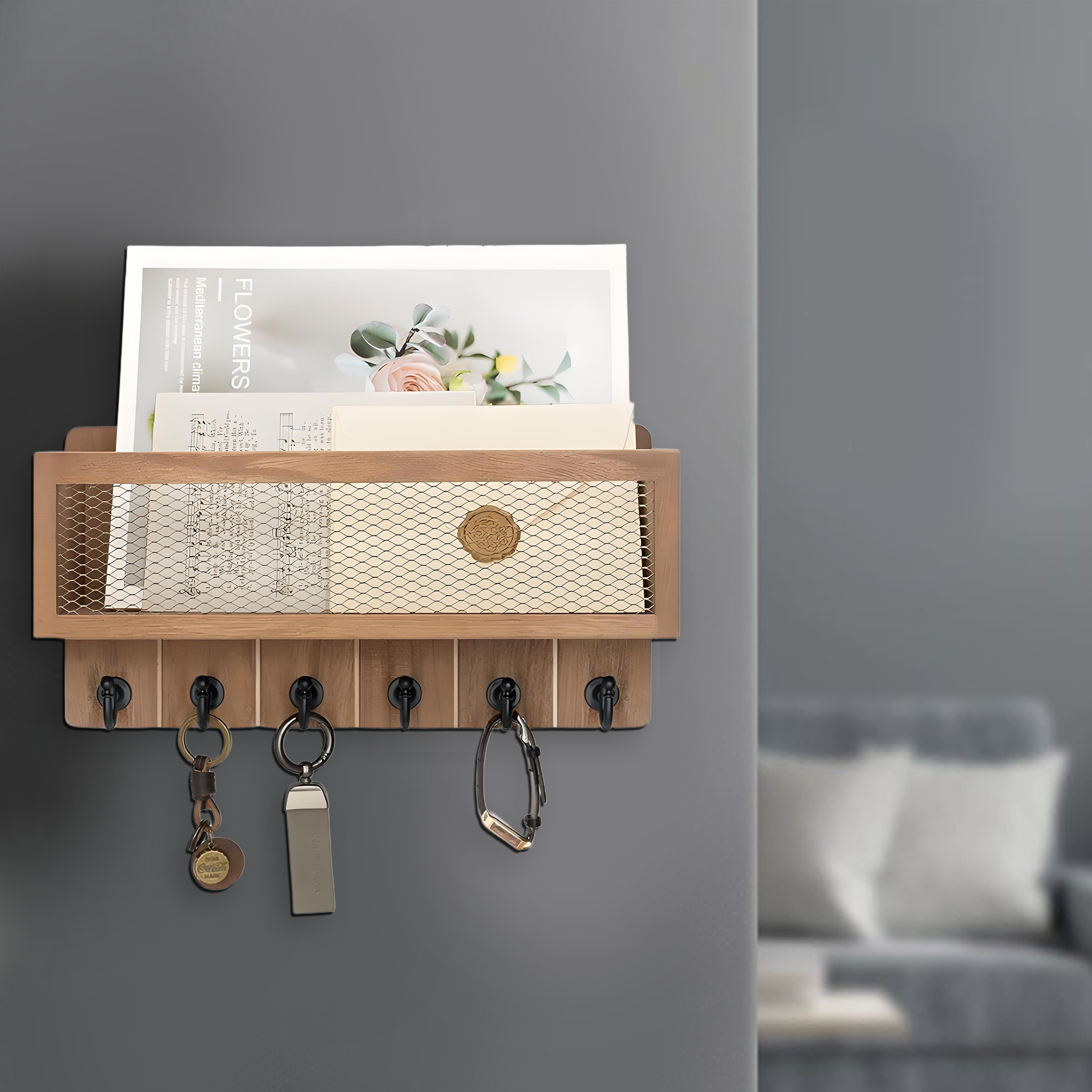 Ein hölzerner Schlüsselhalter mit Schlüsseln und einem kleinen Regal mit Papieren und einer Zeitschrift. Im Hintergrund ist eine Couch unscharf.