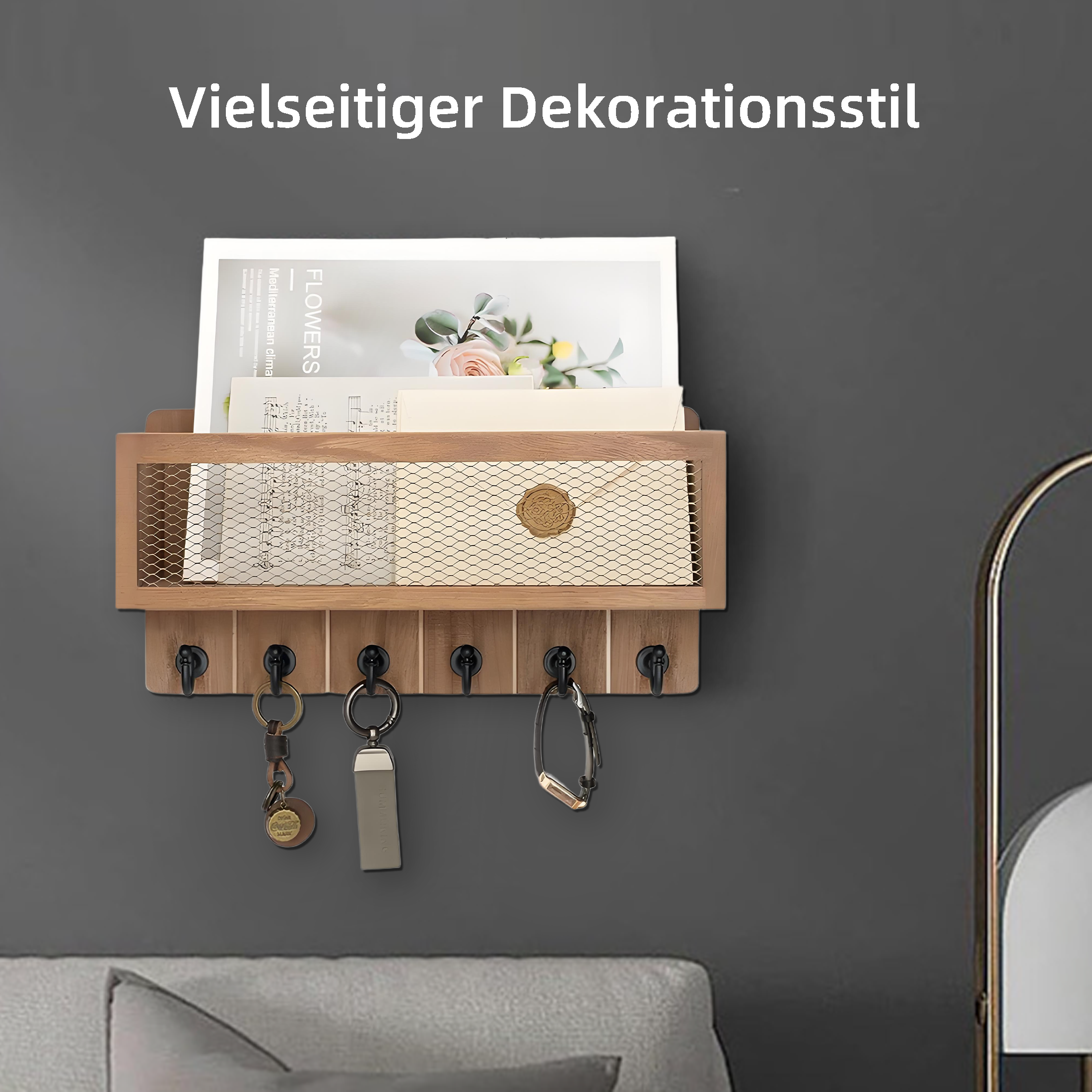 Wand-Schlüsselhalter aus Holz mit Schlüsseln, Magazin und dekorativem Siegel vor grauer Wand.