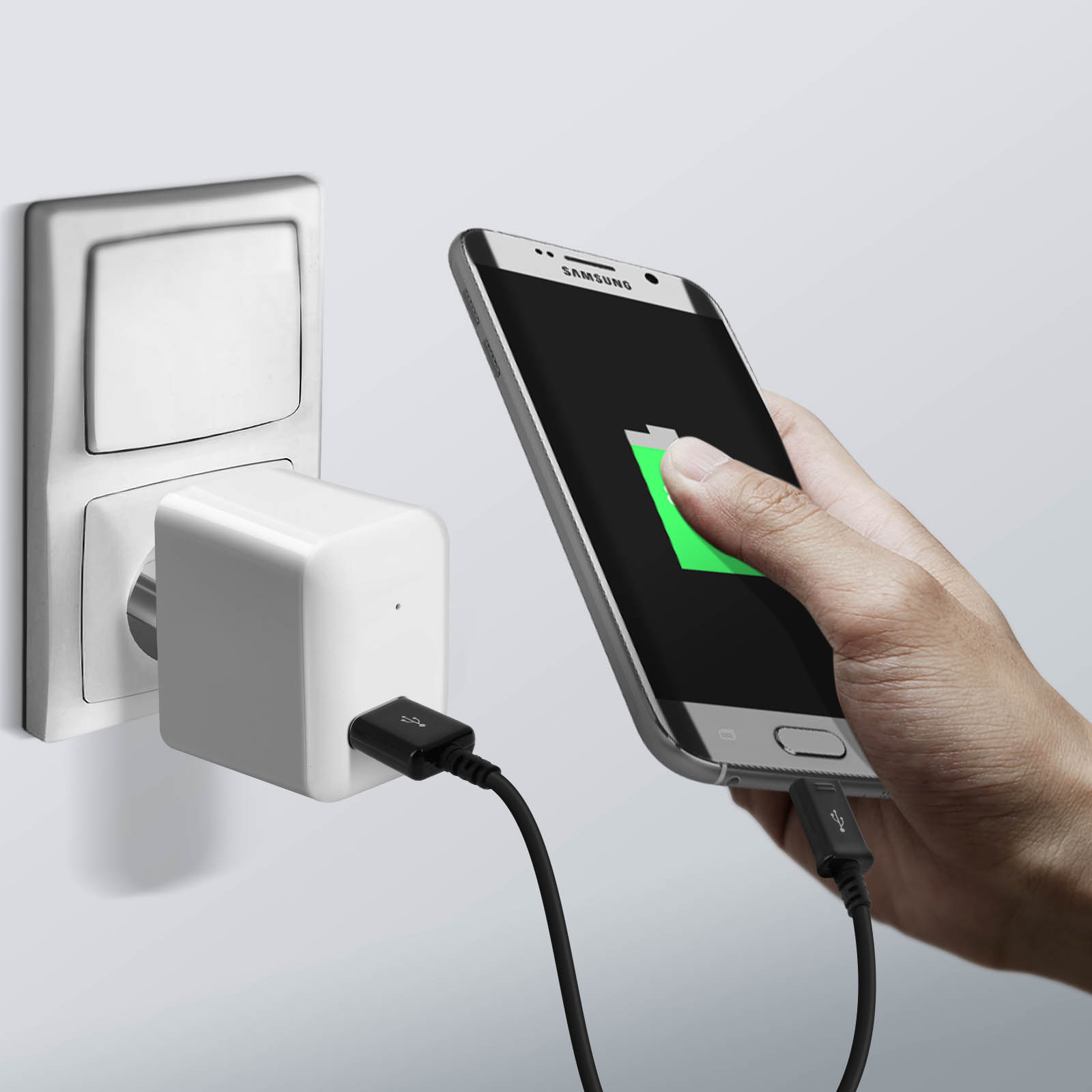 Uno smartphone si sta caricando. Una mano tiene il telefono, mostrando un'icona di ricarica. Un caricatore è collegato al muro.