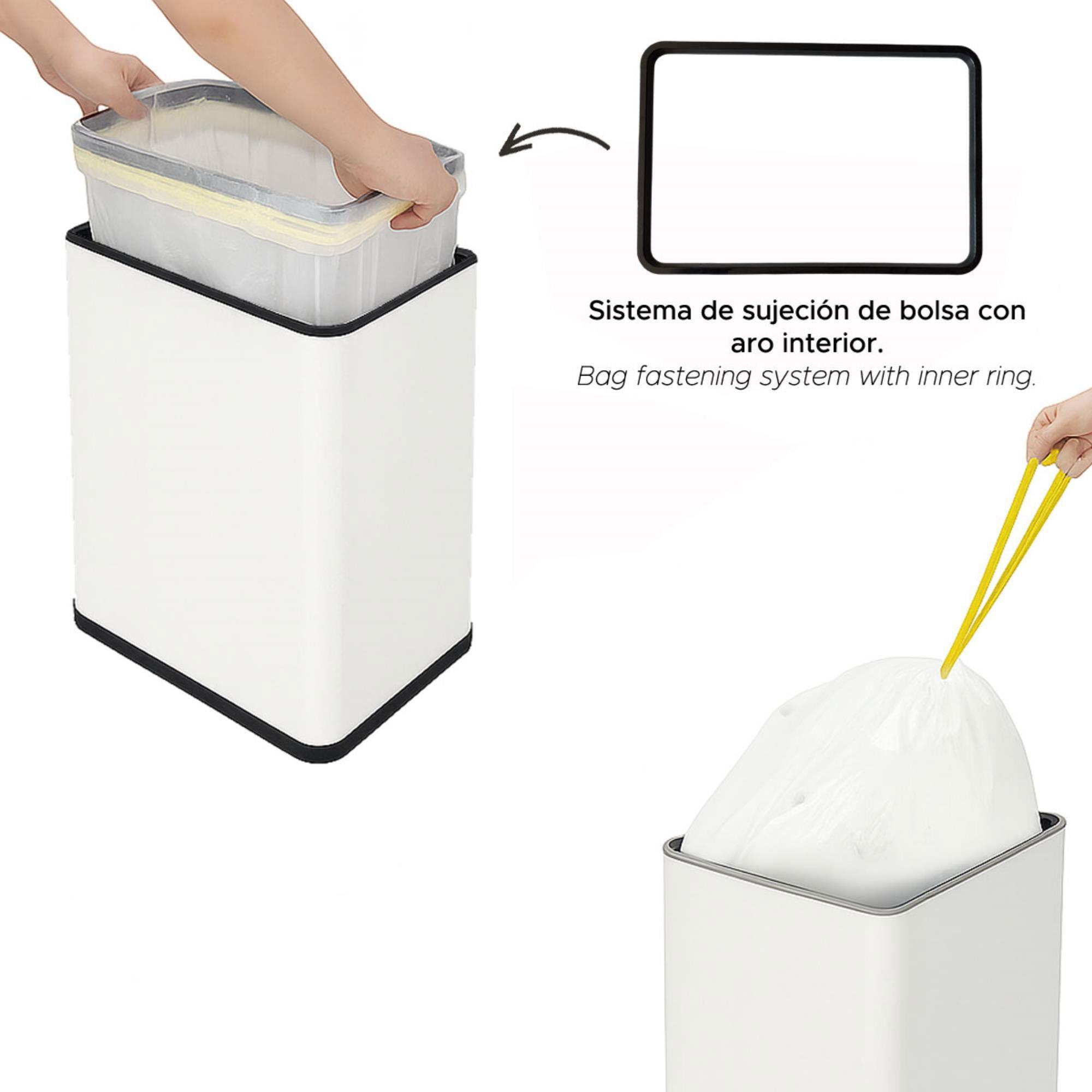 Un cubo de basura blanco con borde negro. Una persona sostiene la bolsa de basura y otra bolsa está en el cubo.