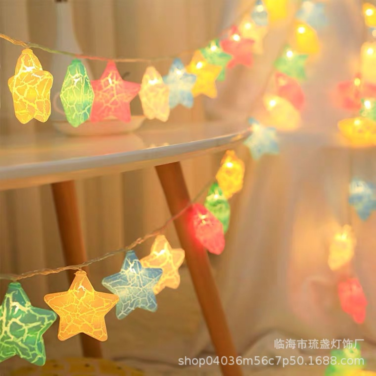 Lichterketten mit sternförmigen Lichtern in mehreren Farben hängen. Die Lichter sind auf einem Tisch. Der Hintergrund ist verschwommen und warm.