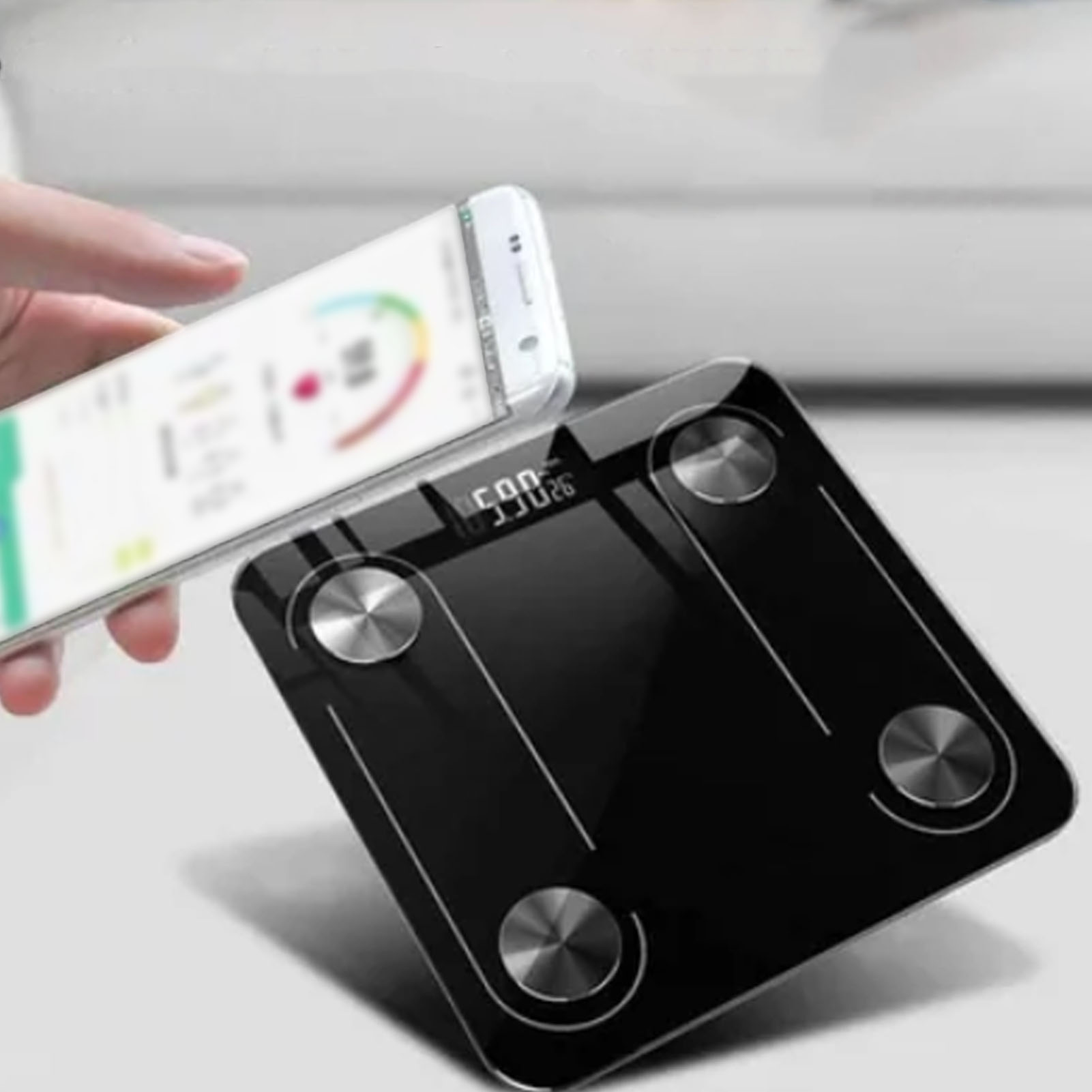 Eine schwarze Digitalwaage mit einem Telefon, das Gesundheitsdaten anzeigt. Eine Hand hält das Telefon über der Waage.