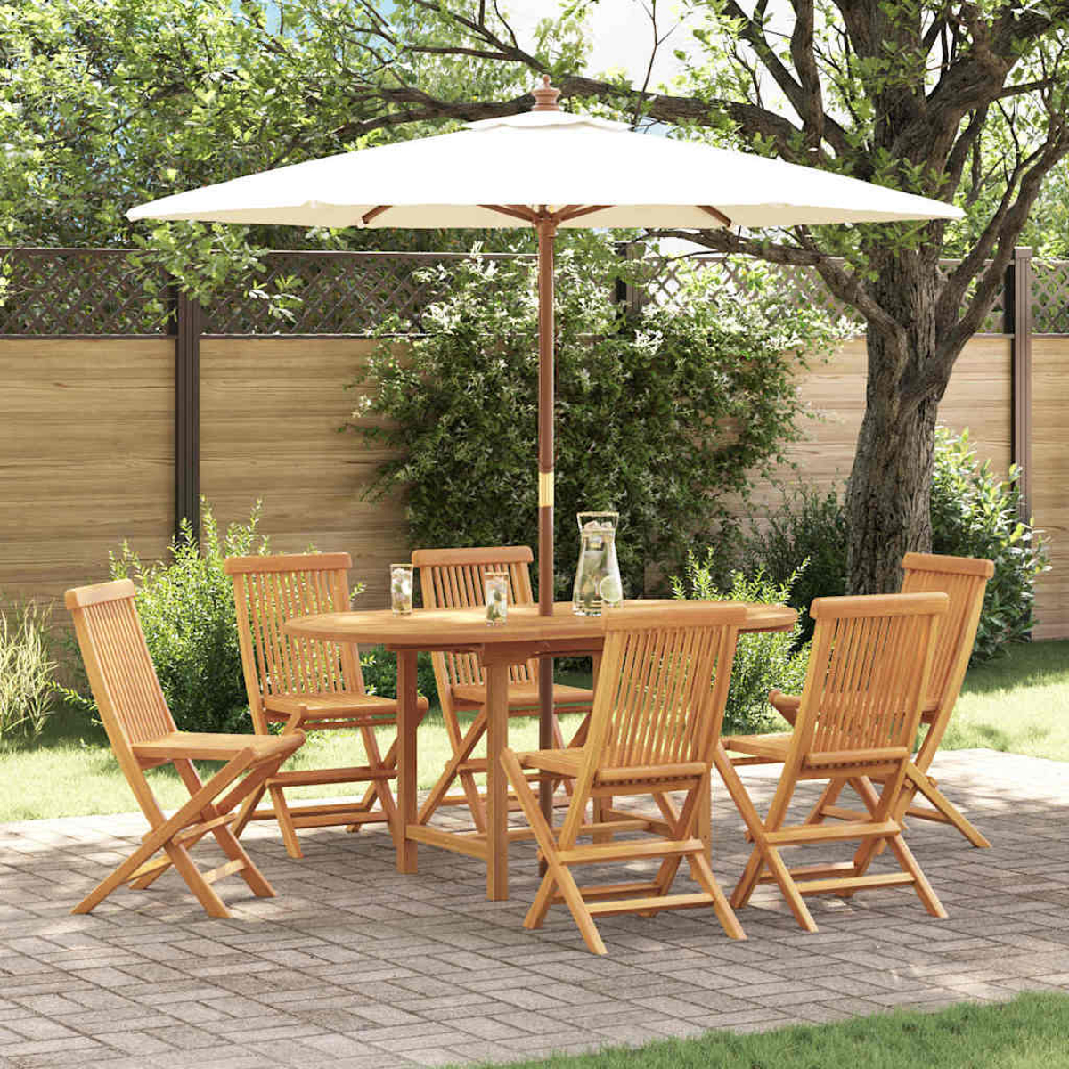 Essgruppe aus Holz im Freien mit Sonnenschirm. Tisch und Stühle auf einer Ziegelterrasse, umgeben von Grün und Holzzaun.