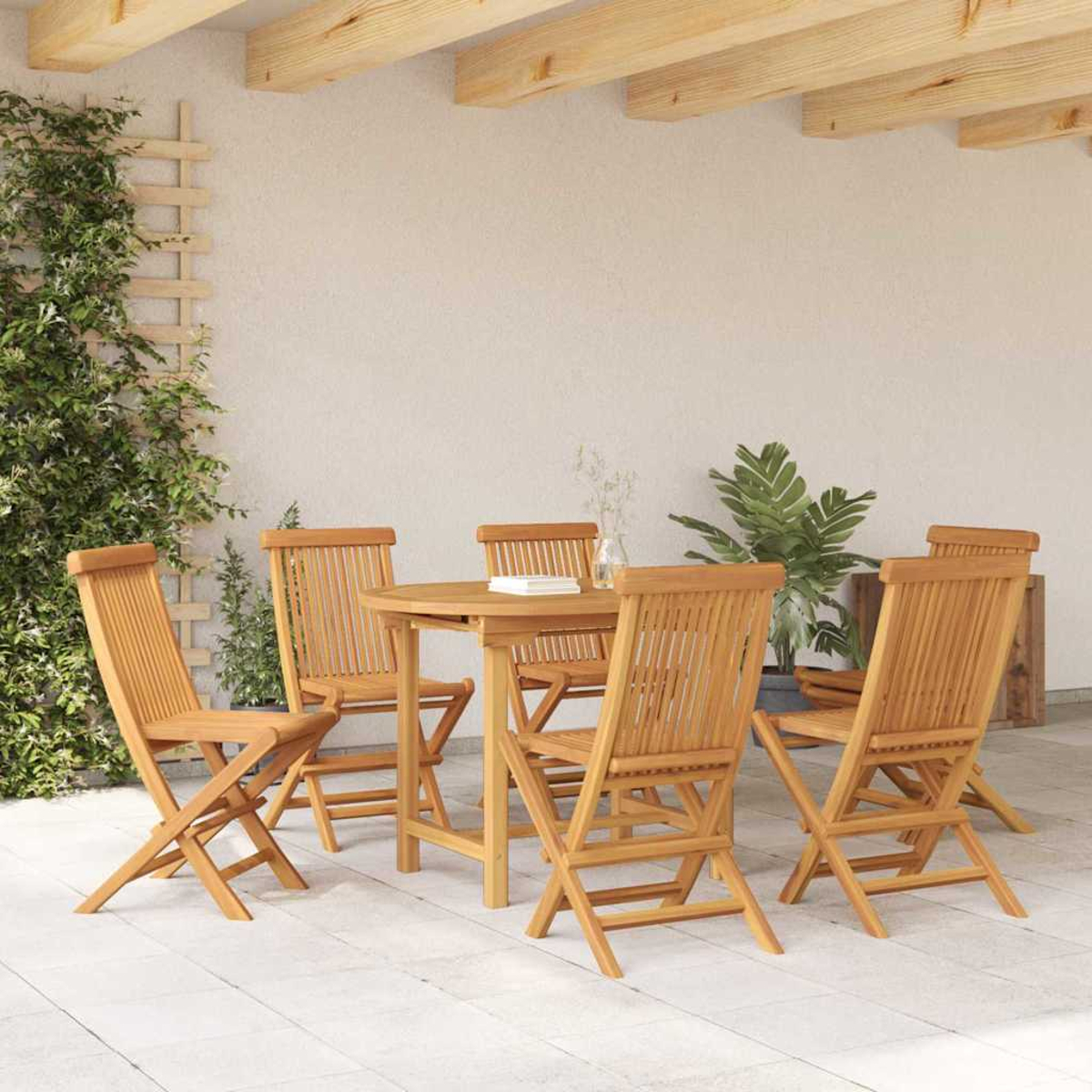 Holztisch und -stühle im Freien auf einer gefliesten Terrasse. Grüne Pflanze und weiße Wand im Hintergrund. Beige Deckenbalken.
