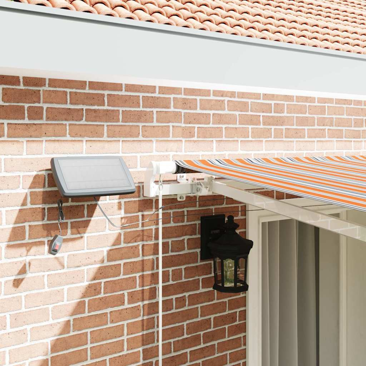 Ziegelmauer mit Markise, Solarpanel und Lampe. Die Markise hat orangefarbene Streifen. Solarpanel an der Wand montiert. Die Lampe ist schwarz.