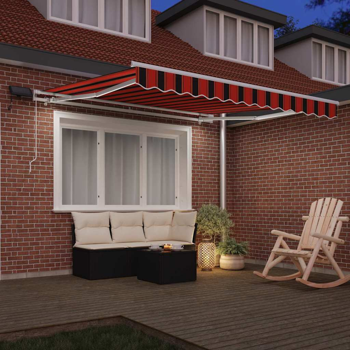 Ein rot-schwarz gestreifter Markisenstoff bedeckt eine Terrasse mit Möbeln. Ein Schaukelstuhl und ein Sofa sind vor einer Backsteinmauer sichtbar.