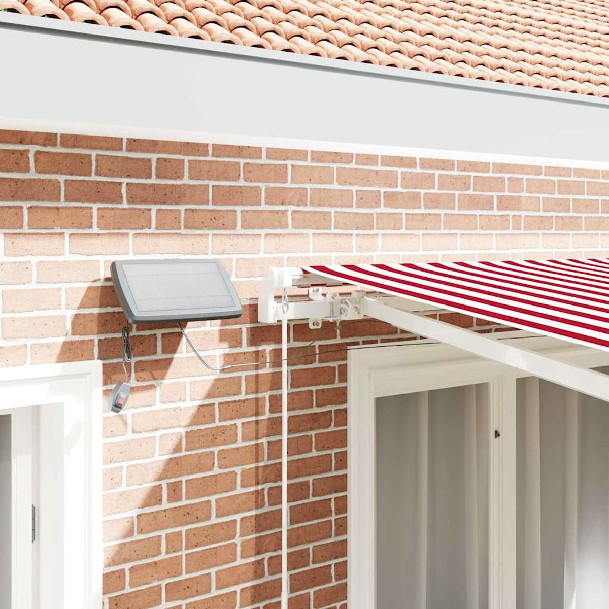 Eine Backsteinmauer mit einer rot-weiß gestreiften Markise. Ein Solarpanel und eine Fernbedienung sind an der Wand befestigt.