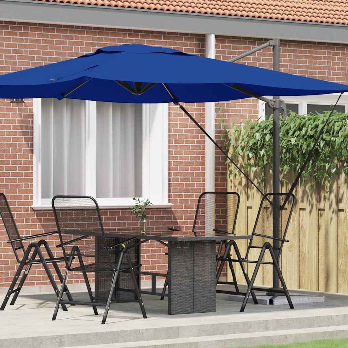 Un set da patio all'aperto con ombrellone blu, tavolo e sedie. Un muro di mattoni sullo sfondo.