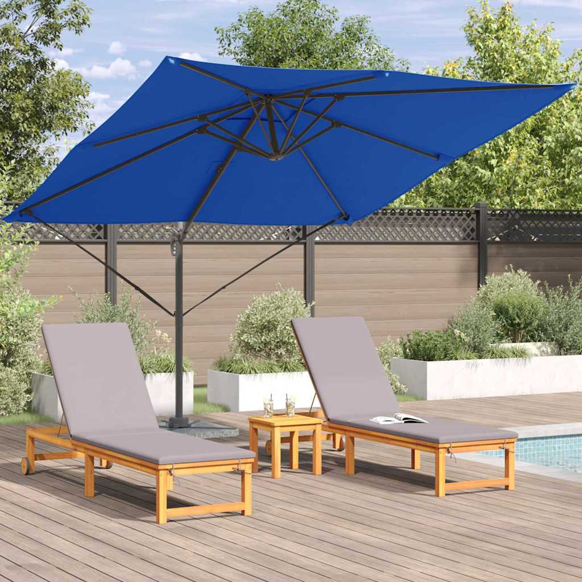 Un ombrello blu ombreggia due lettini imbottiti grigi e un tavolino. Un ponte di legno circonda una piscina.