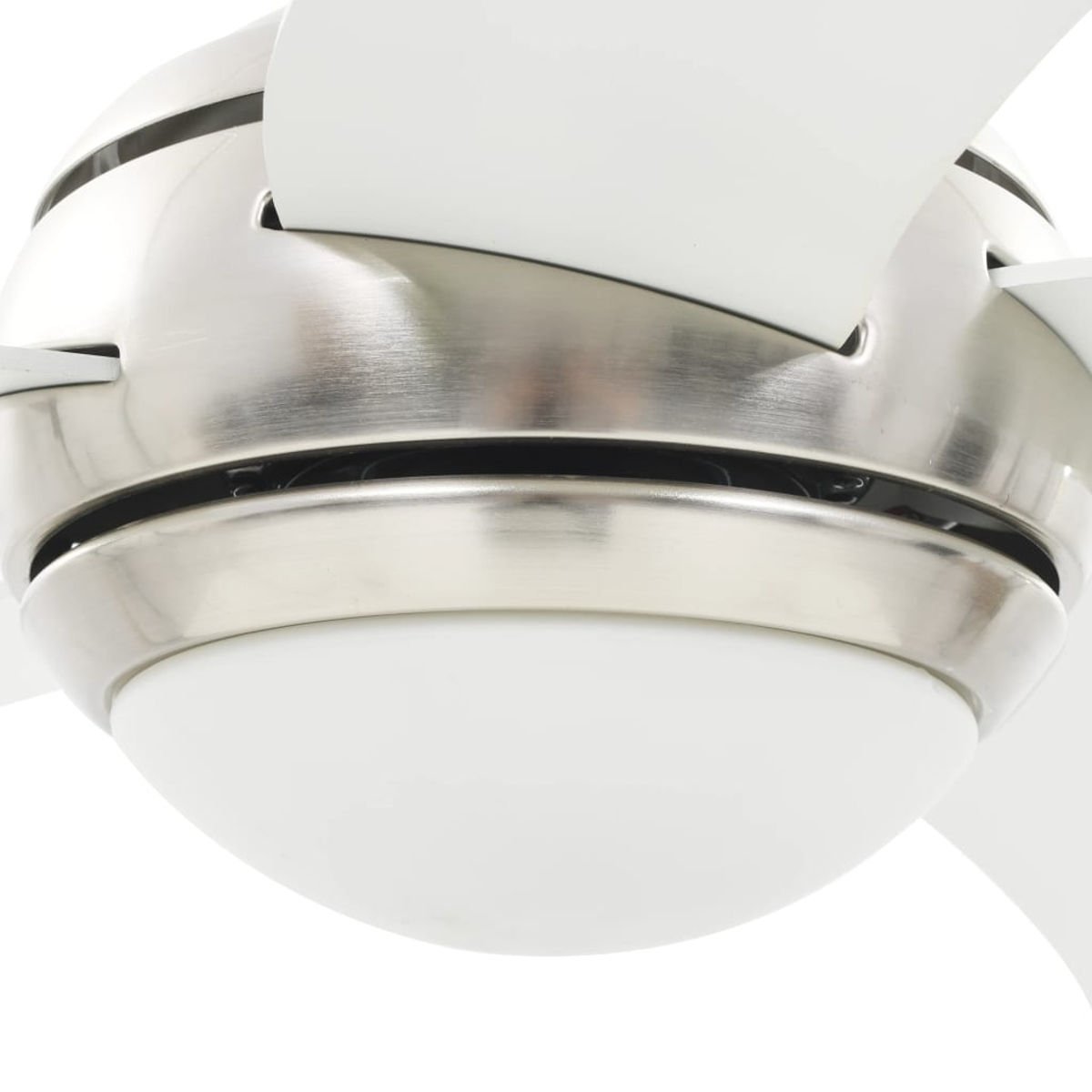 Primo piano di un ventilatore da soffitto con pale bianche, alloggiamento motore argentato e un apparecchio di illuminazione bianco. Lo sfondo è bianco.