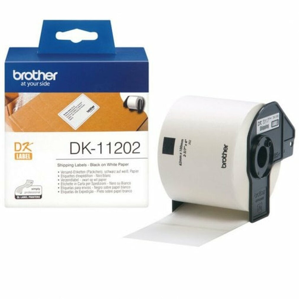 Eine Brother DK-11202 Versandetikettenbox und eine weiße Etikettenrolle liegen auf einer weißen Oberfläche. Auf der Box steht 'brother' und 'at your side'.