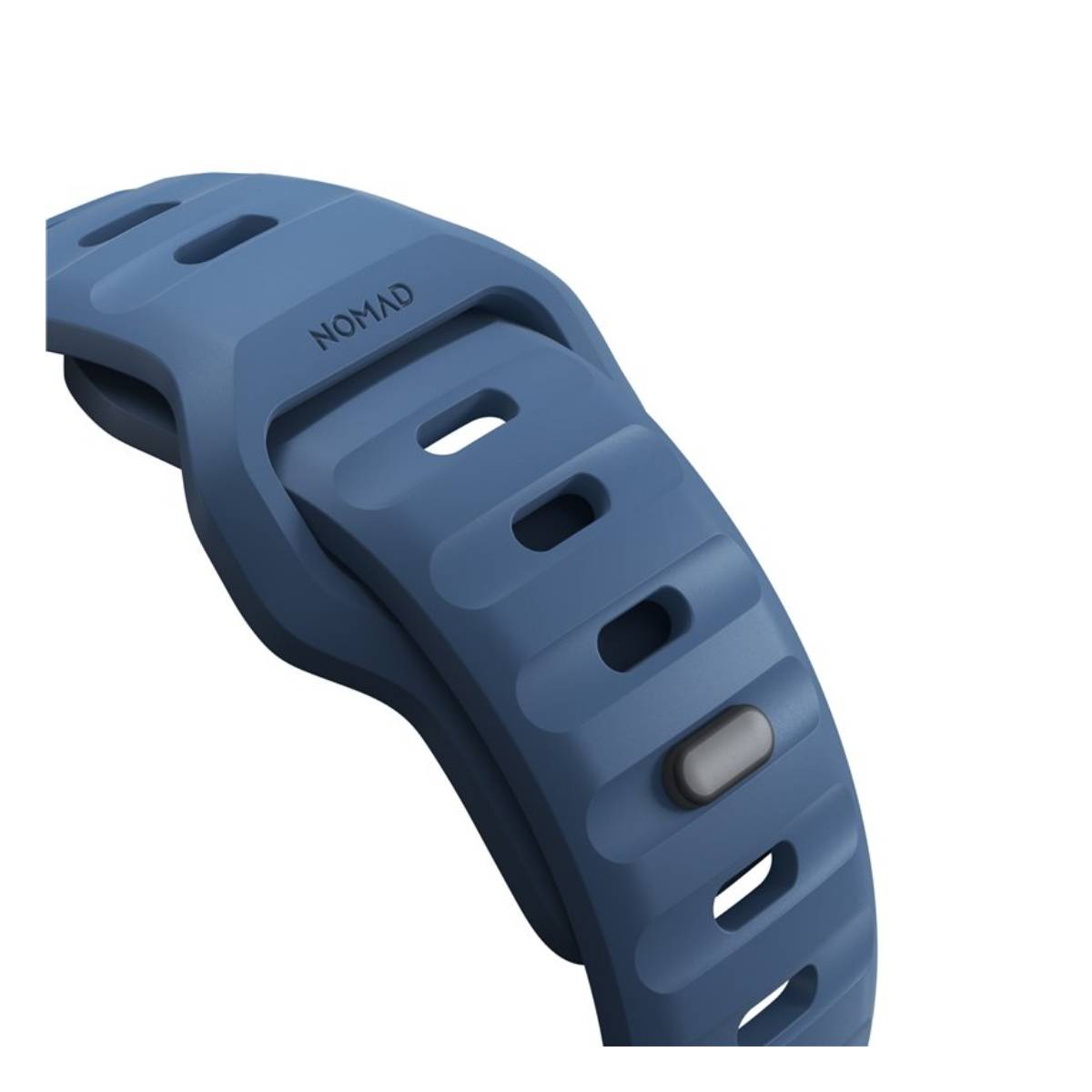 Primer plano de una correa de reloj azul con el nombre 'NOMAD' visible. Tiene agujeros rectangulares y un botón gris, sobre fondo blanco.