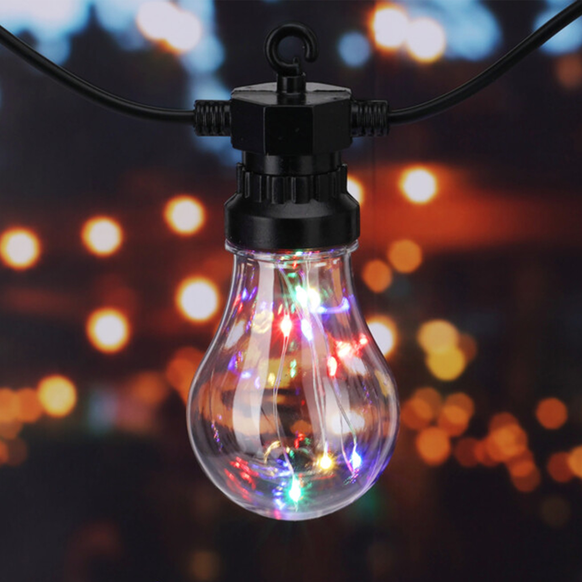 Una bombilla transparente con luces LED multicolores en su interior. La bombilla está unida a un cable negro con un gancho. Fondo borroso.