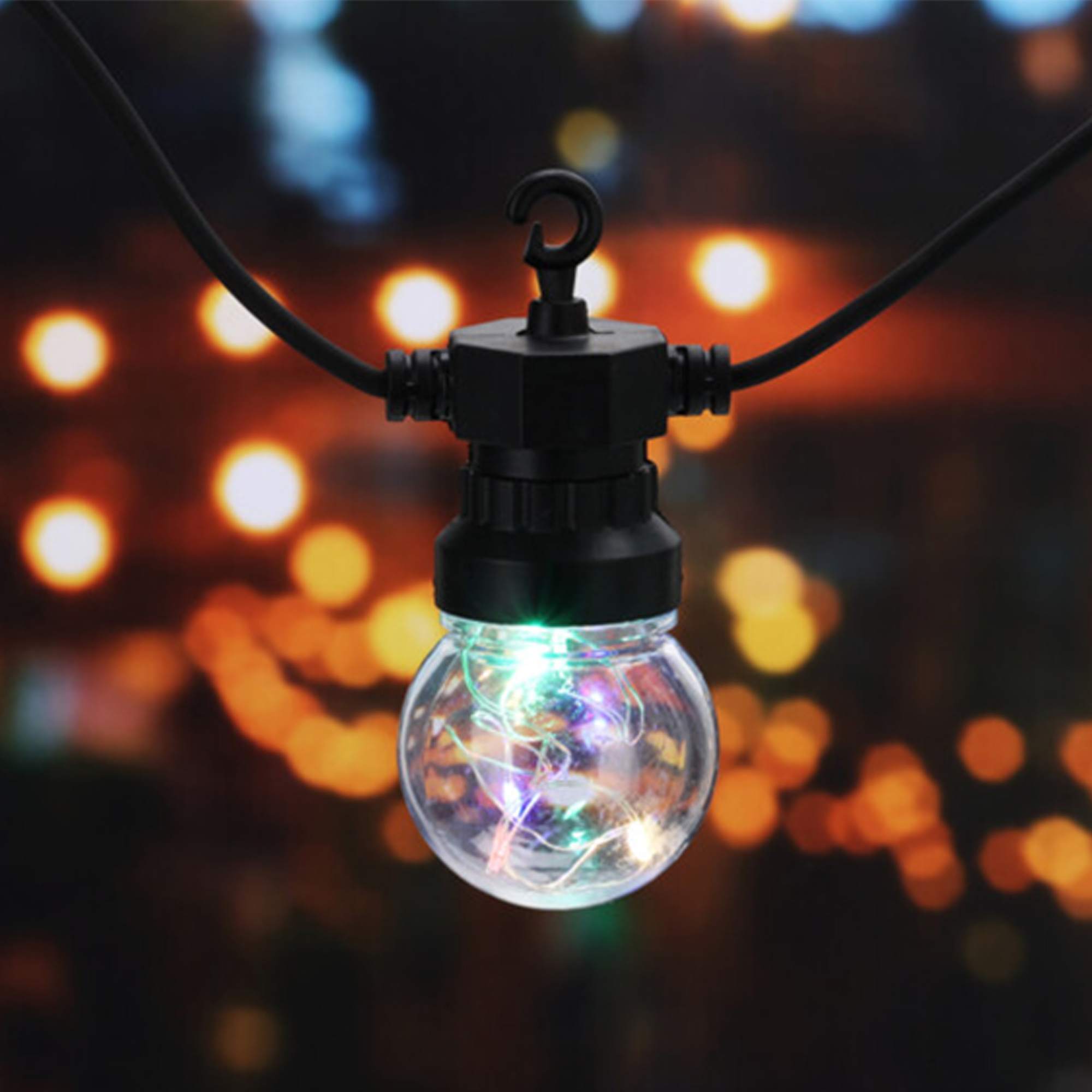 Primer plano de una bombilla de cadena de luces con luces internas coloridas, colgando contra un fondo borroso de luces.