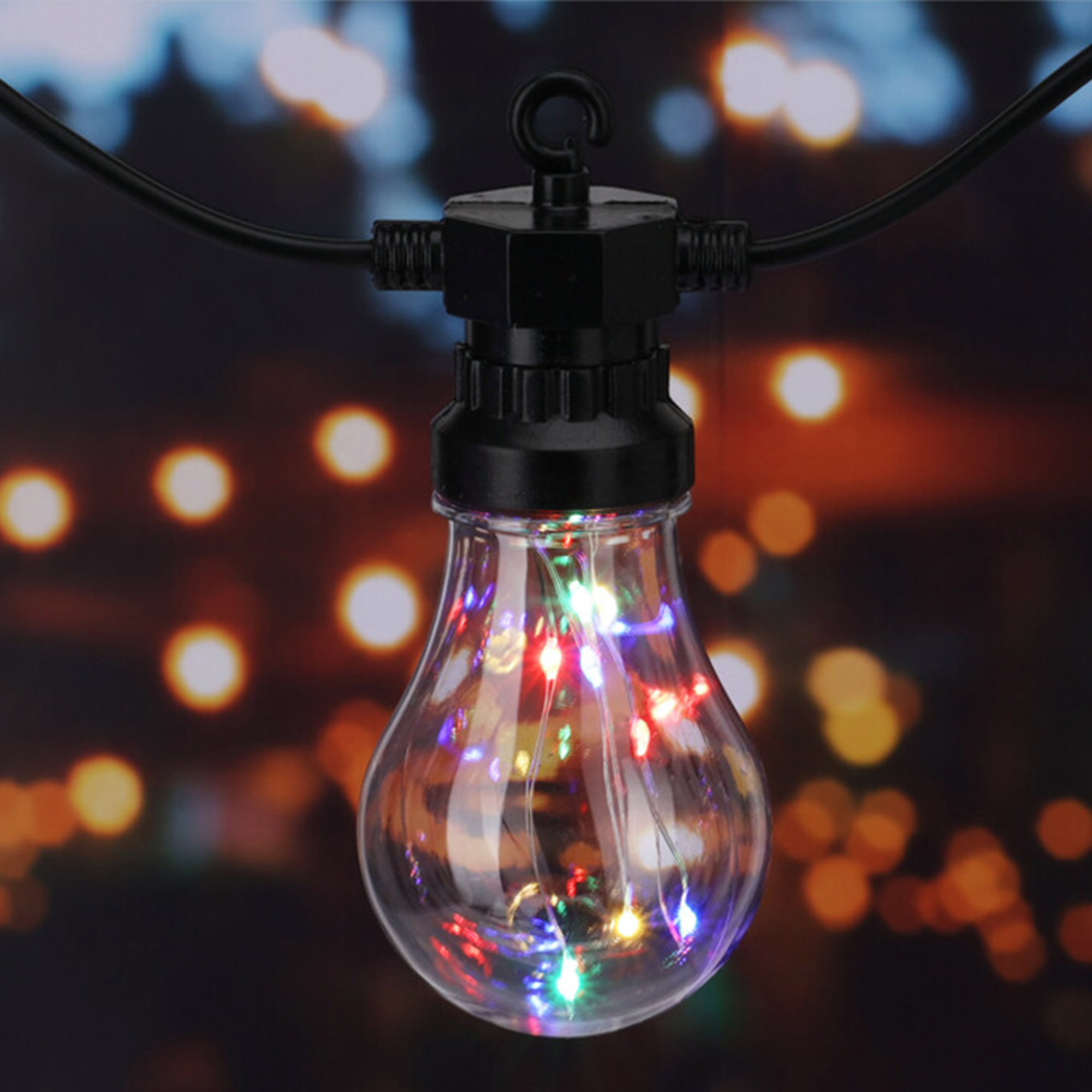 Bombilla transparente con luces de colores, accesorio negro y cable negro. Fondo bokeh con tonos cálidos.