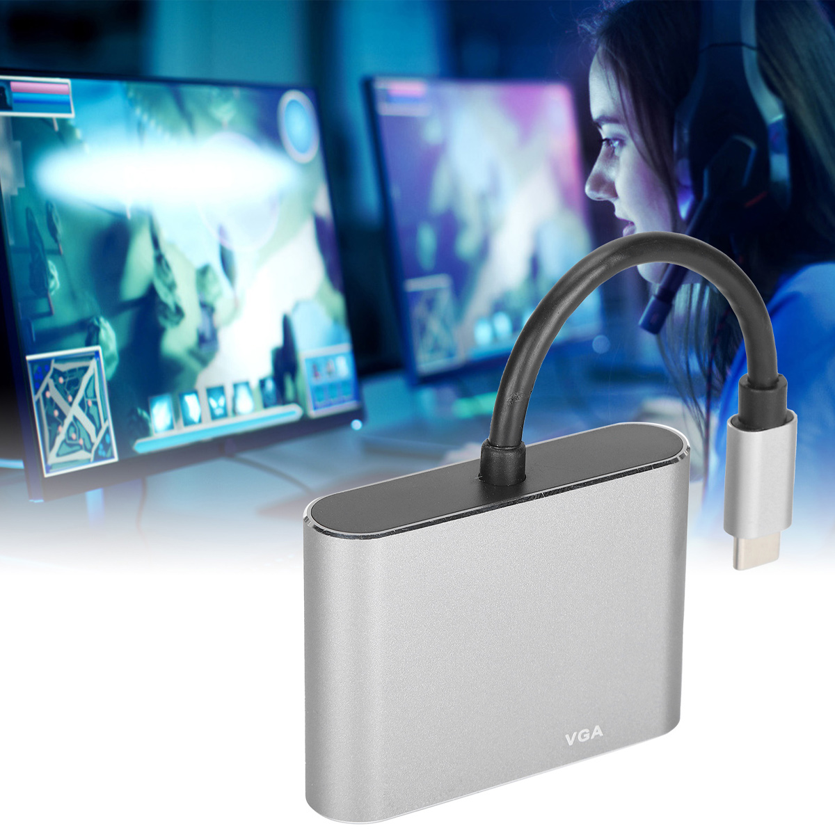 Ein silberner VGA-Adapter ist mit einem schwarzen Kabel verbunden. Im Hintergrund ist eine Person mit Headset zu sehen, die auf einen Monitor schaut.