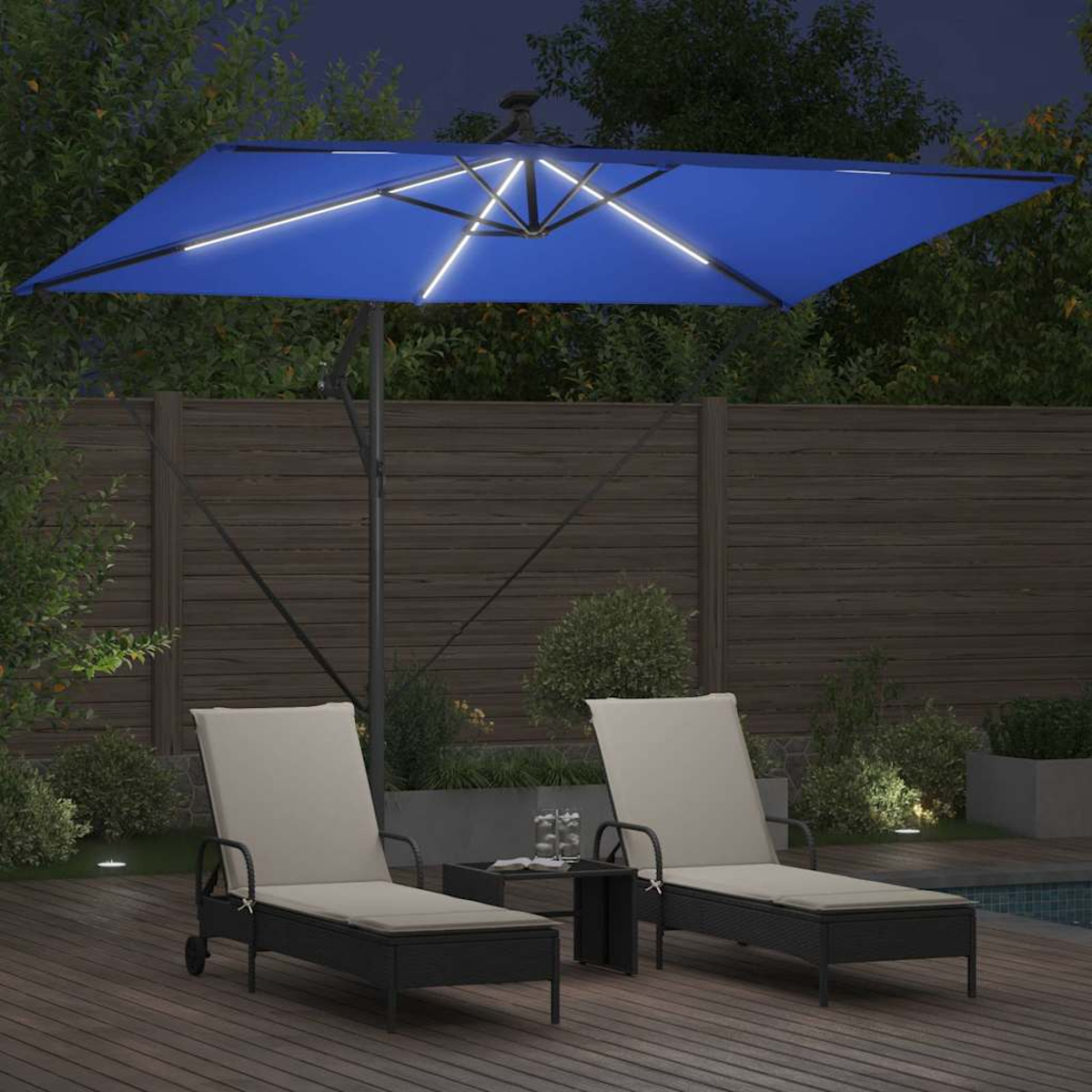 Scena notturna con un ombrello blu illuminato. Due lettini, un tavolo e una piscina sono nel cortile. Recinzione in legno sullo sfondo.