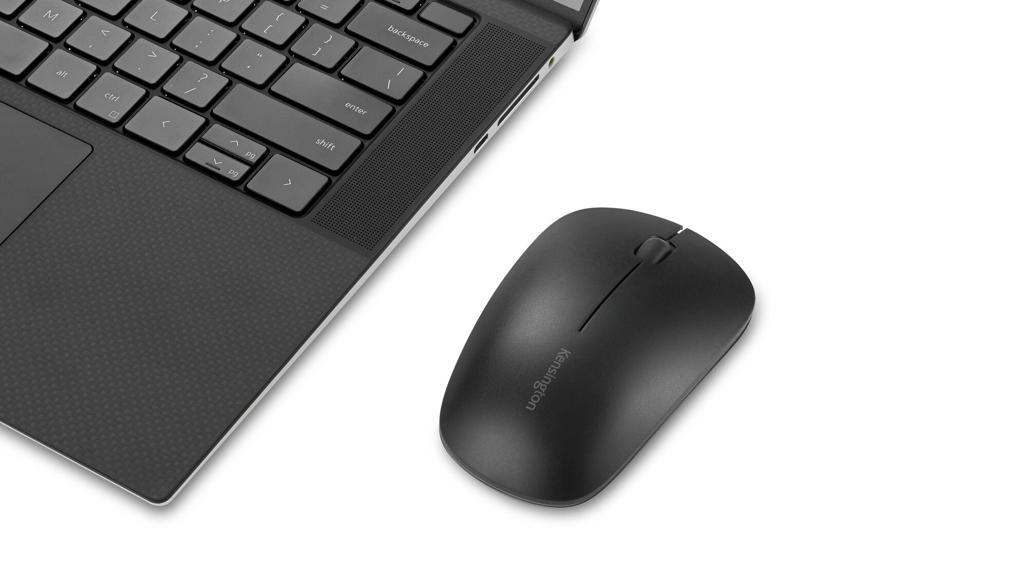 A black laptop keyboard and a black Kensington mouse are on a white surface. The mouse is next to the laptop.