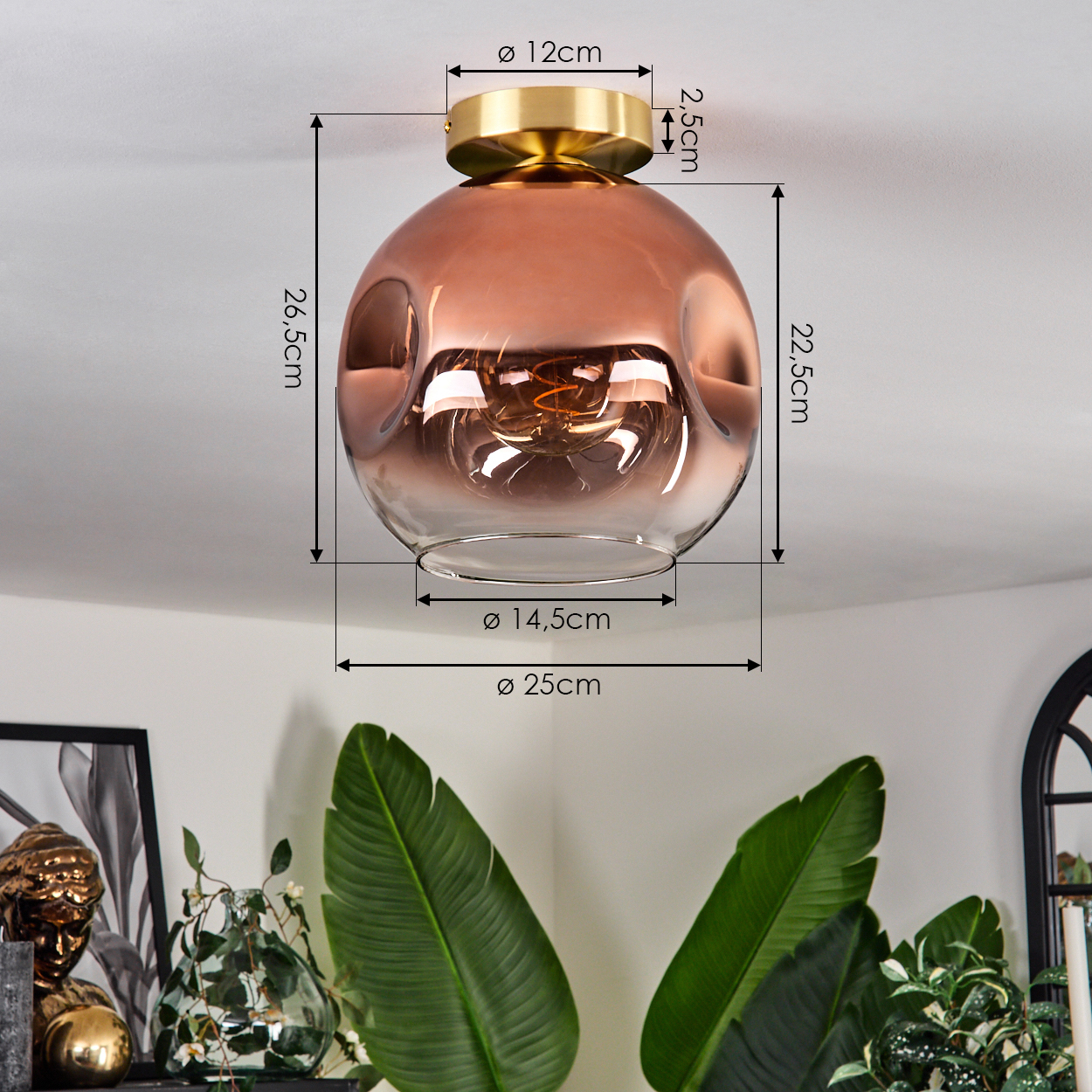 Eine Deckenlampe mit kupferfarbenem Glasschirm. Abmessungen sind angegeben. Grüne Pflanzen und ein dekorativer goldener Buddha im Hintergrund.
