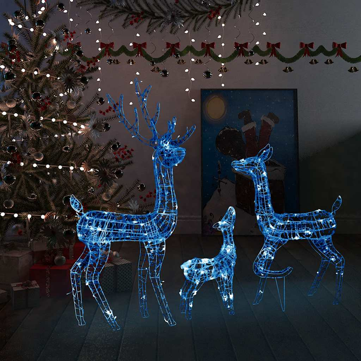 Beleuchtete Drahtgestell-Rentierdekorationen. Ein Weihnachtsbaum mit Lichtern und ein Gemälde vom Weihnachtsmann sind im Hintergrund.