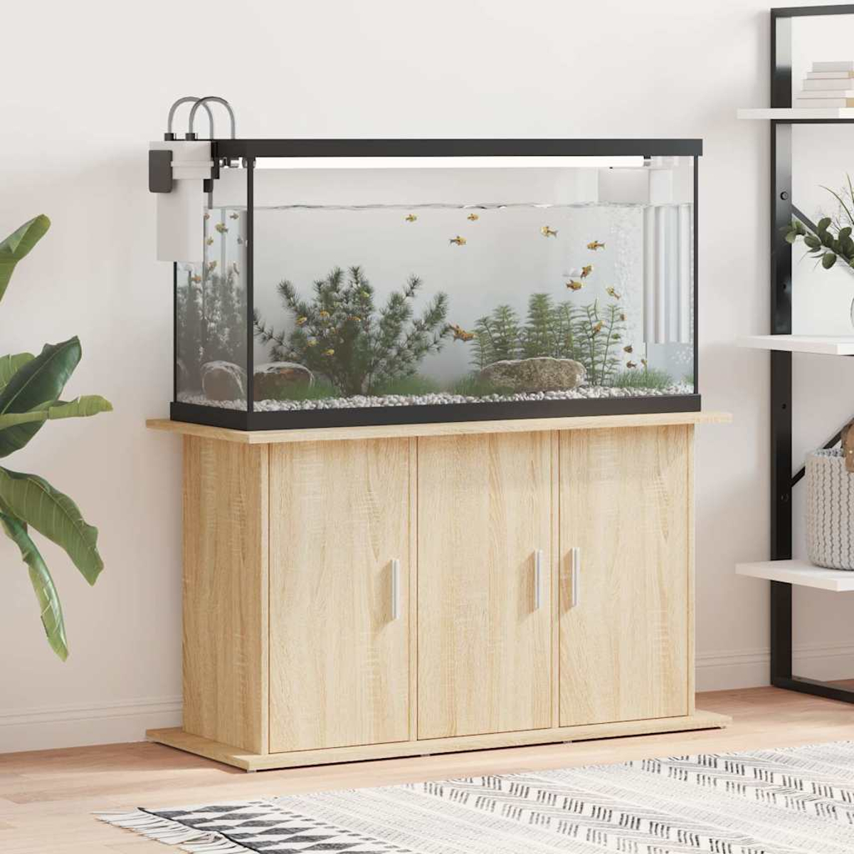 Ein Aquarium mit Fischen, Pflanzen und Steinen steht auf einem Holzschrank. Links befindet sich ein Filter und rechts ein Regal.