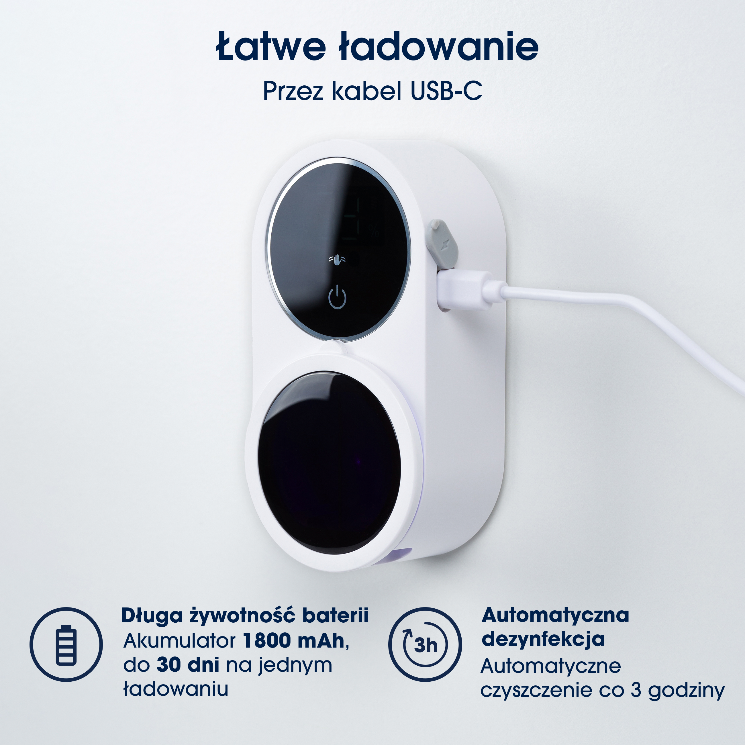 Białe urządzenie z dwoma czarnymi okręgami na białej ścianie. Podłączony jest kabel USB. Widoczny jest również tekst po polsku.