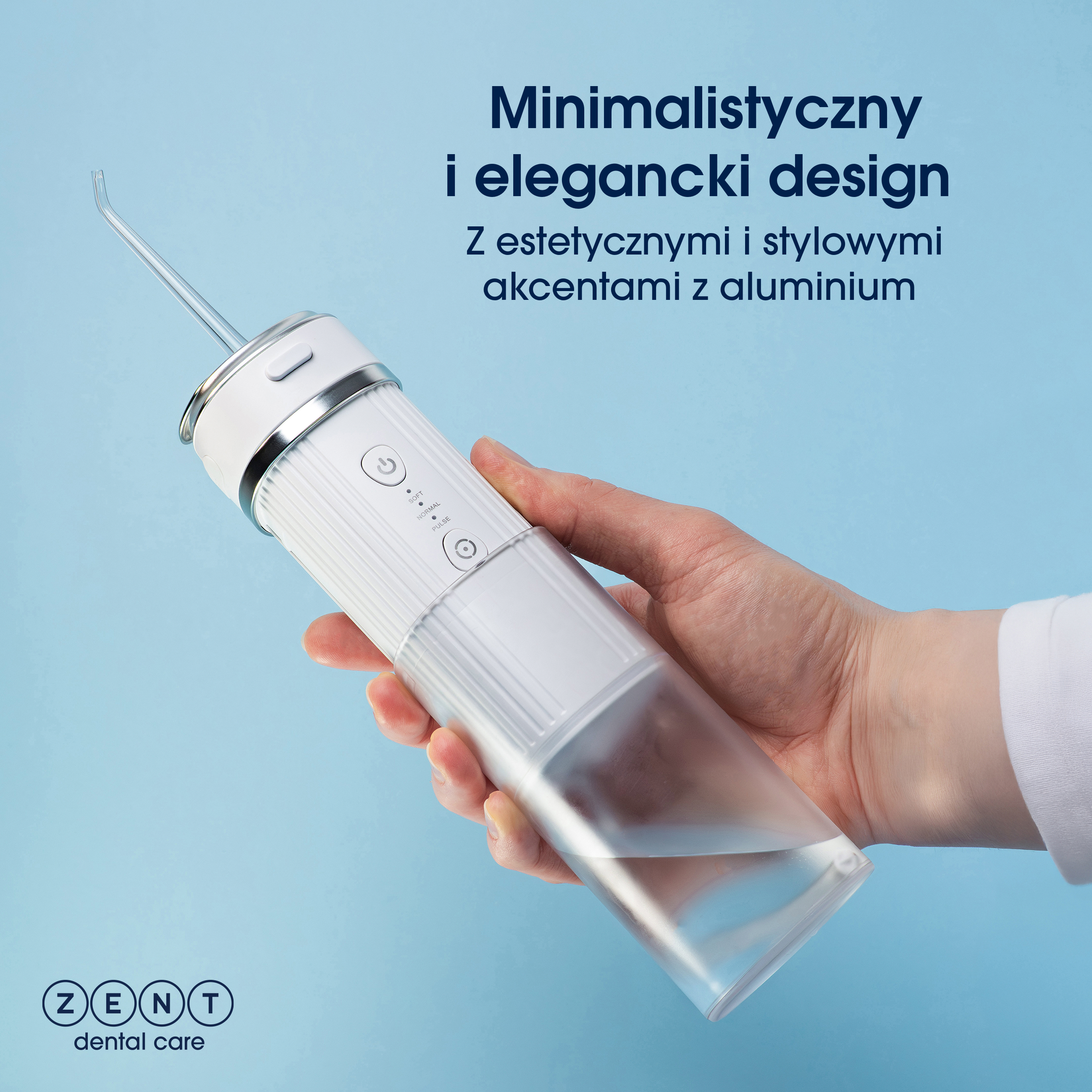Biały i przezroczysty irygator trzymany jest w dłoni na niebieskim tle. Powyżej znajduje się tekst.