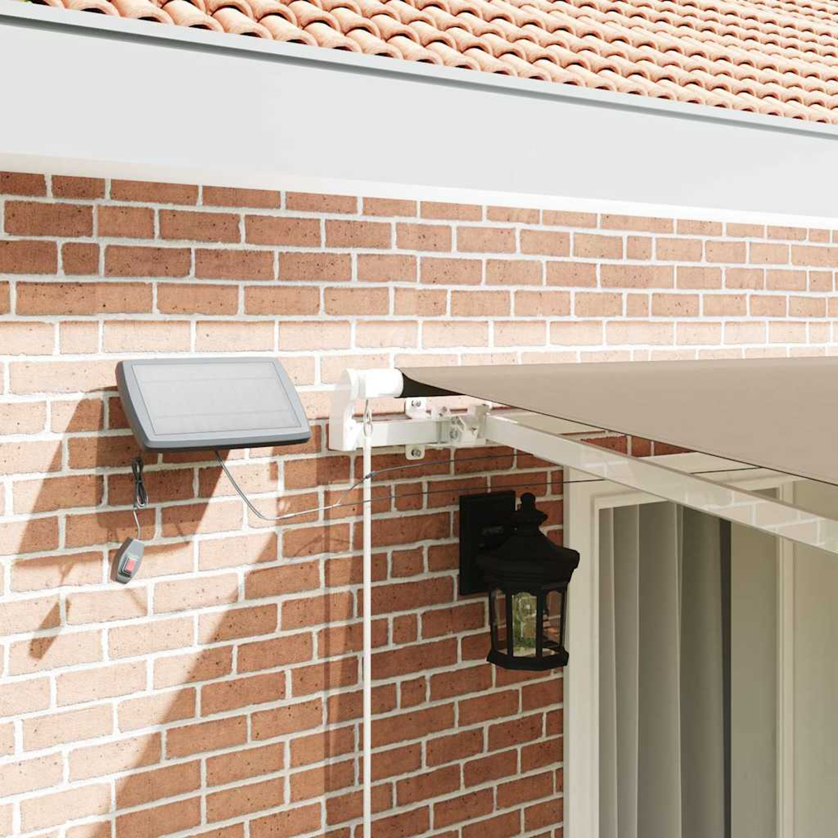 Eine Backsteinmauer mit Solarpanel und Markise. Eine schwarze Laterne hängt an der Wand. Dachziegel sind oben sichtbar.