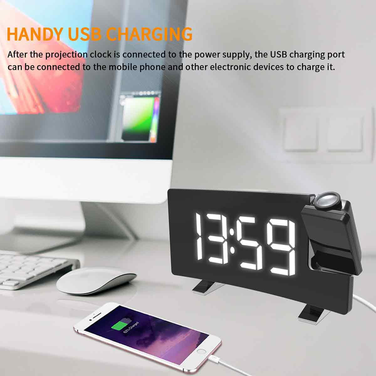 Digitaluhr mit der Anzeige 13:59, aufladendes Smartphone, weiße Maus, Tastatur und Computermonitor auf einem Schreibtisch. Uhr mit USB-Anschluss.