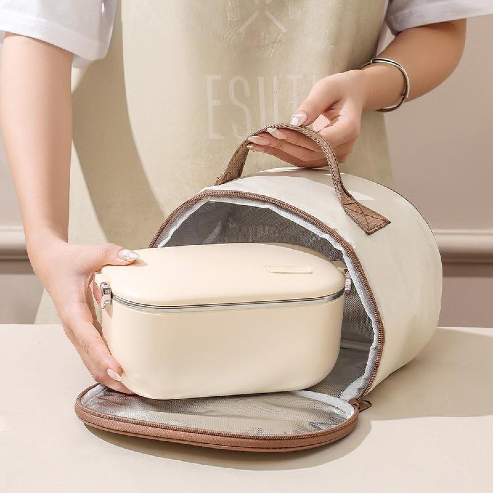 Eine Person hält eine beige Lunchtasche und öffnet sie, um eine passende rechteckige Lunchbox zu enthüllen. Die Tasche hat einen braunen Griff.