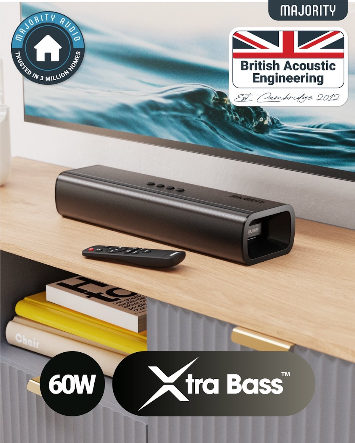 A black soundbar and remote on a wooden cabinet. A TV is in the background. Logos for Majority Audio and Xtra Bass are visible.