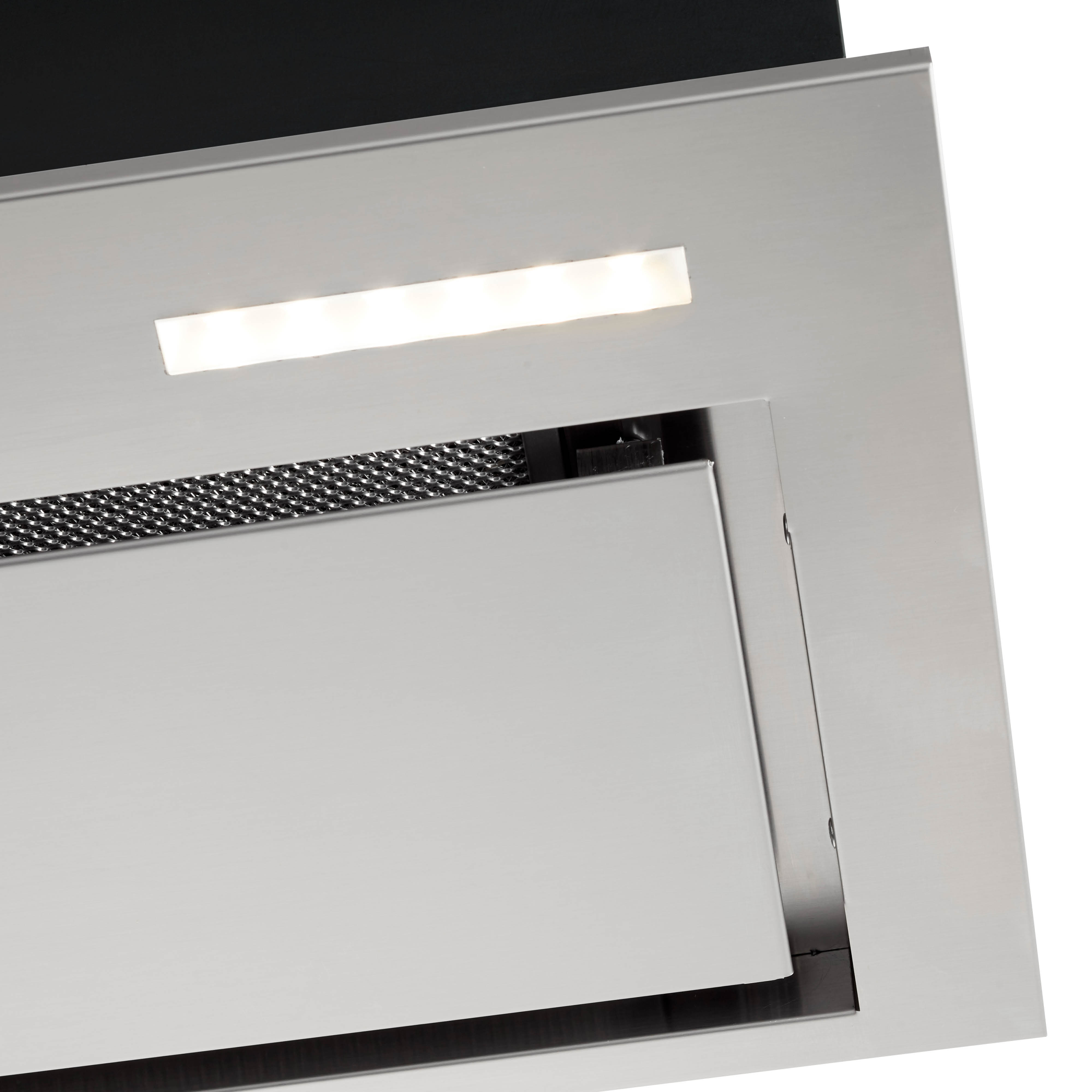 Een roestvrijstalen afzuigkap met een lamp erboven. De kap heeft een gaasfilter en een wit, plat oppervlak.