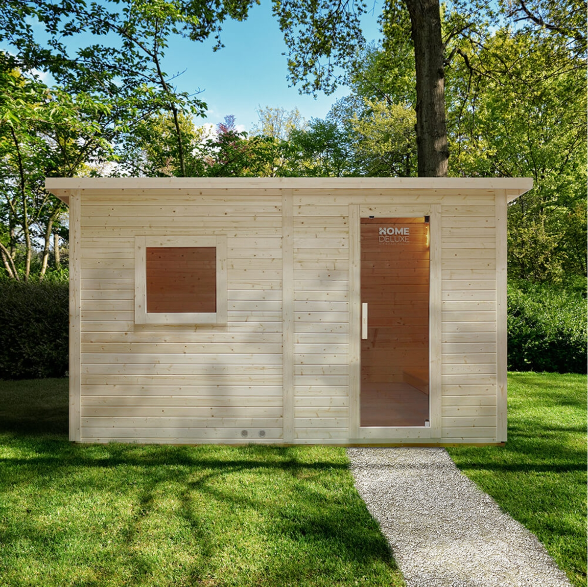 Holzsaunahütte mit Glastür, Fenster und Kiesweg in einer grünen Rasenfläche, umgeben von Bäumen.