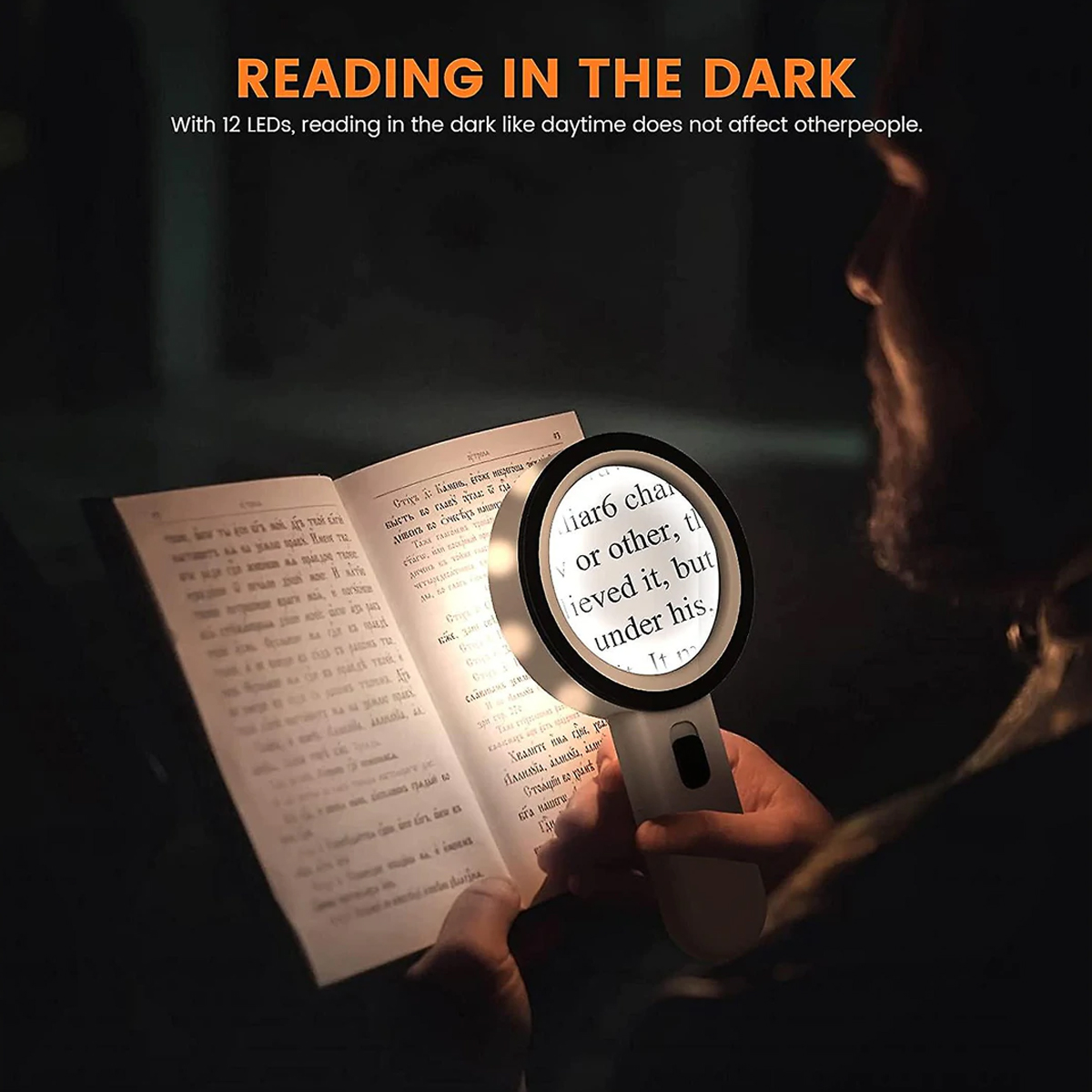 Eine Person liest im Dunkeln ein Buch mit einer Lupe. Das Glas beleuchtet den Text.