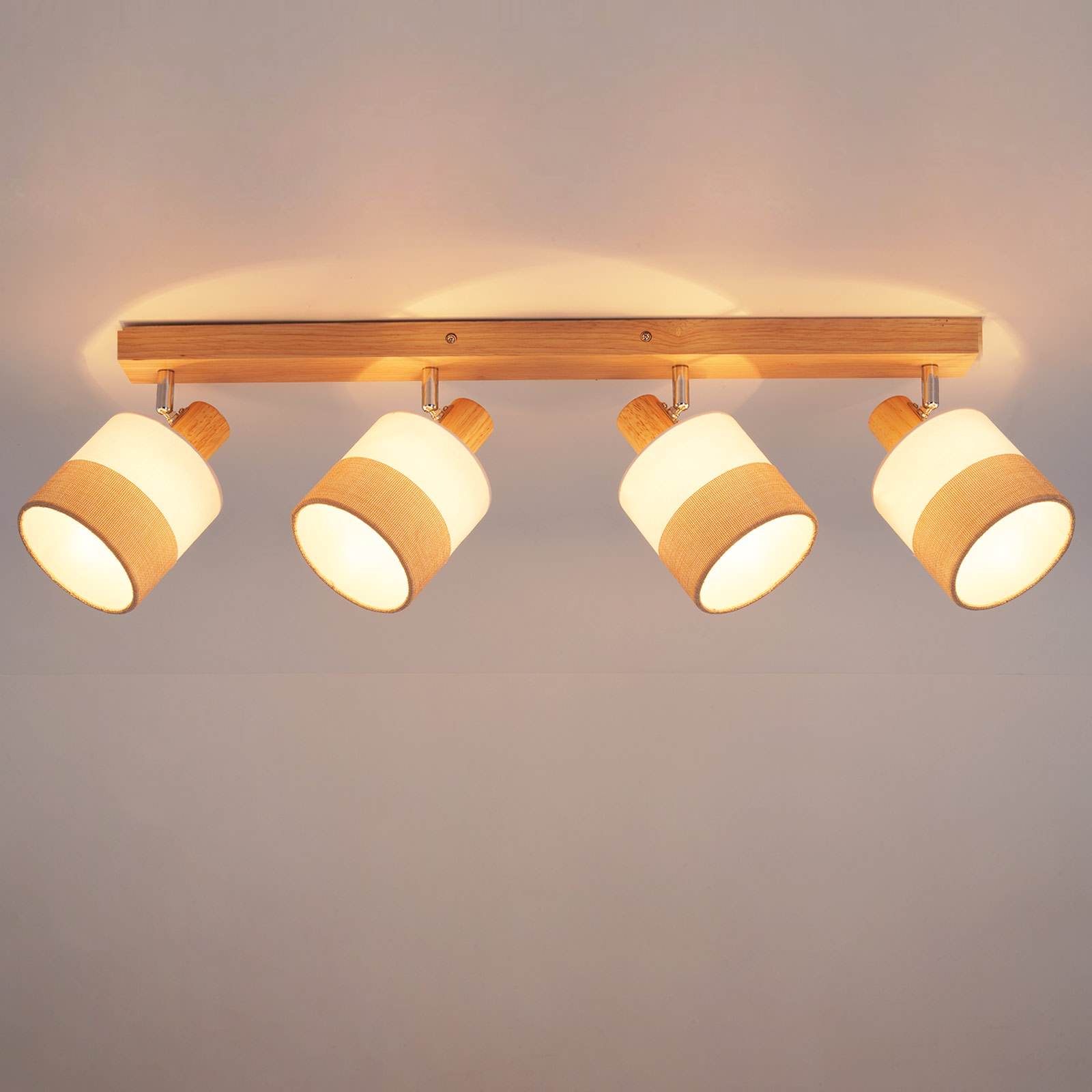 Drewniana belka z czterema regulowanymi lampami. Każda lampa ma biały klosz z beżowym paskiem materiału.
