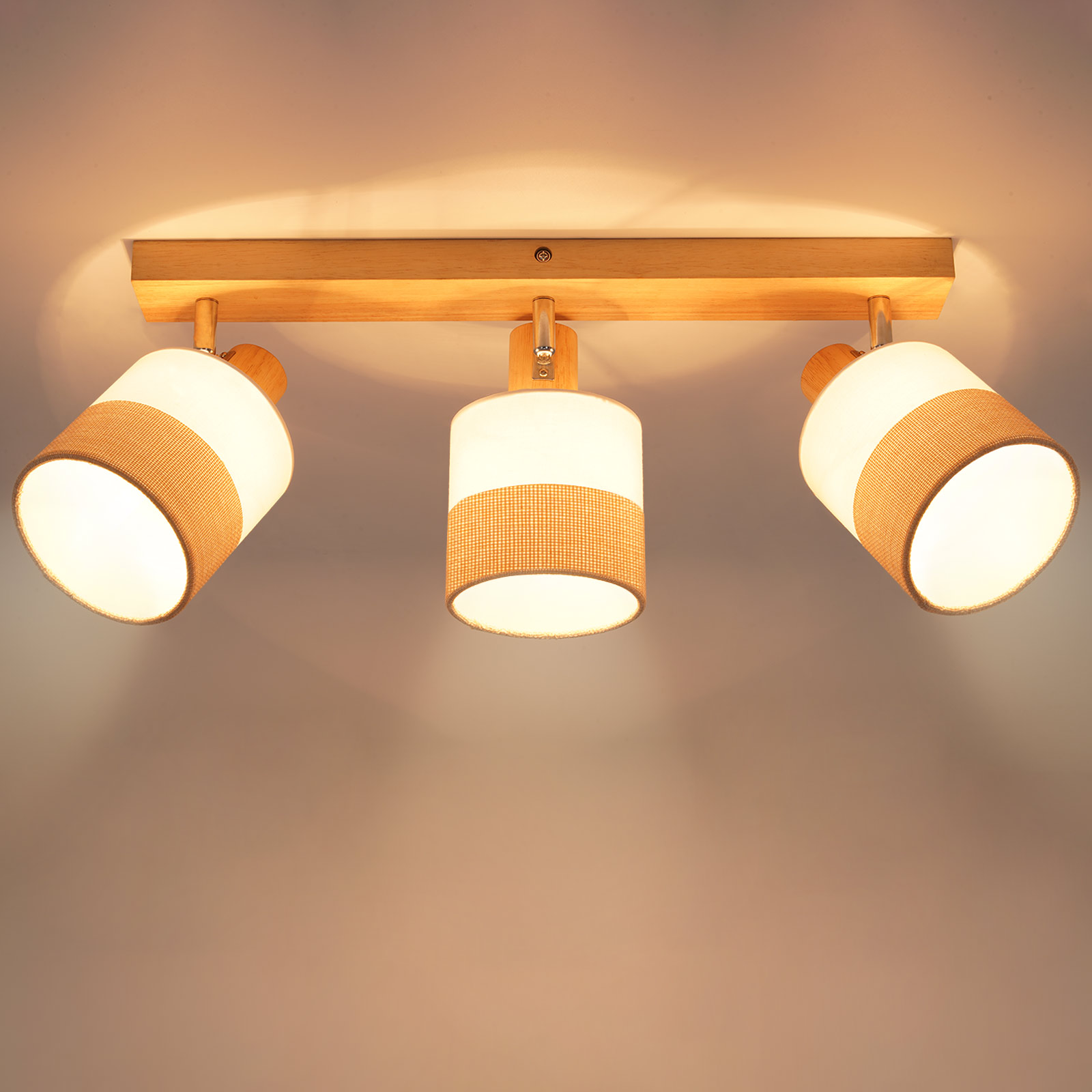 Trzyelementowa oprawa oświetleniowa. Drewniana podstawa z trzema cylindrycznymi lampami. Każda lampa ma biały klosz i beżowy tkany pasek.