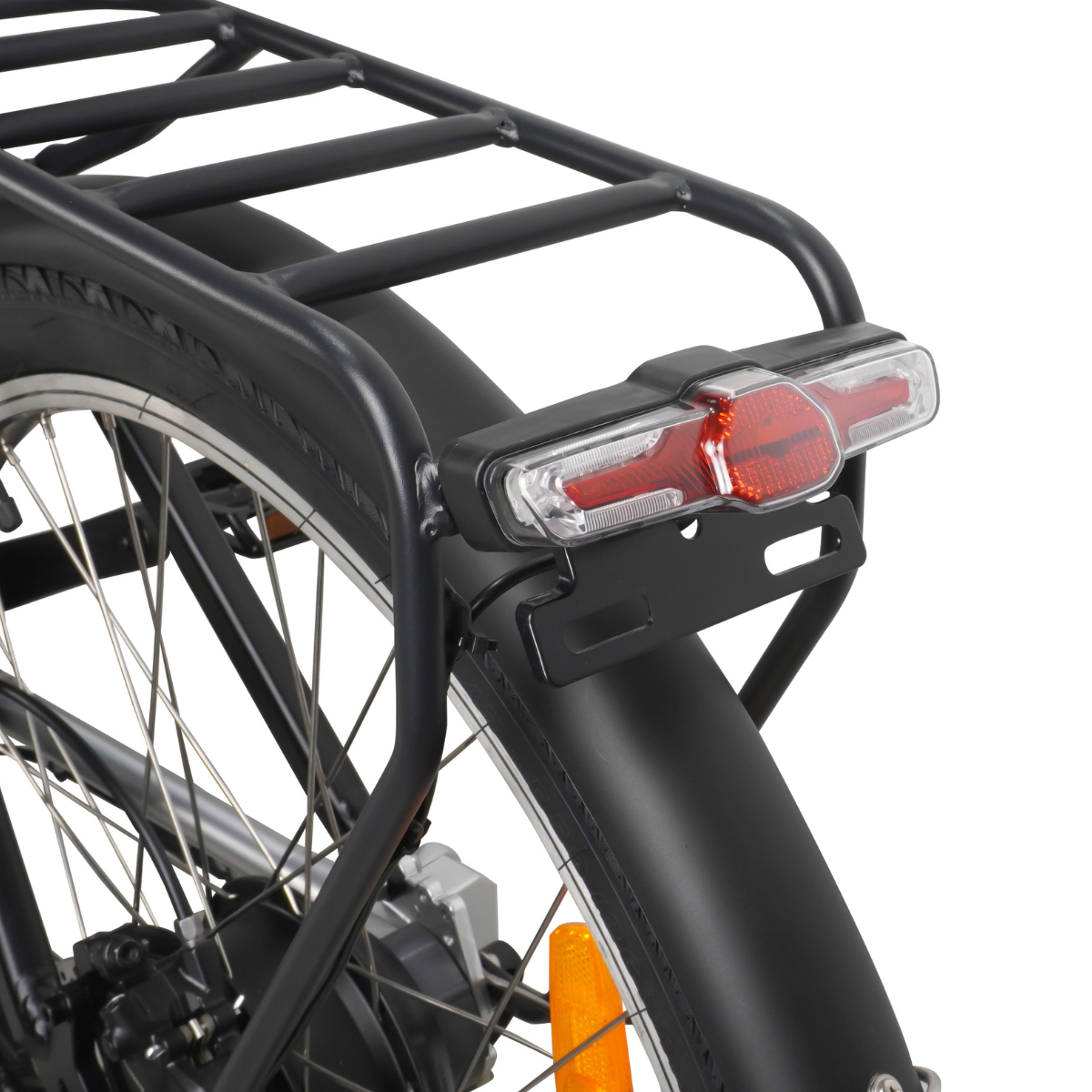 Zbliżenie na tył czarnego roweru. Widoczne są koło, błotnik, bagażnik oraz czerwone i przezroczyste światło tylne.