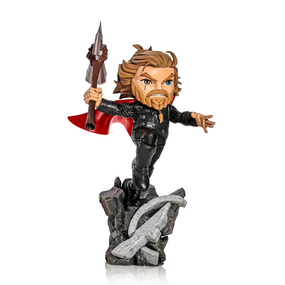 Statuetta di Thor con mantello rosso, che tiene un'arma, su una base rocciosa. La statuetta ha capelli e barba biondi.